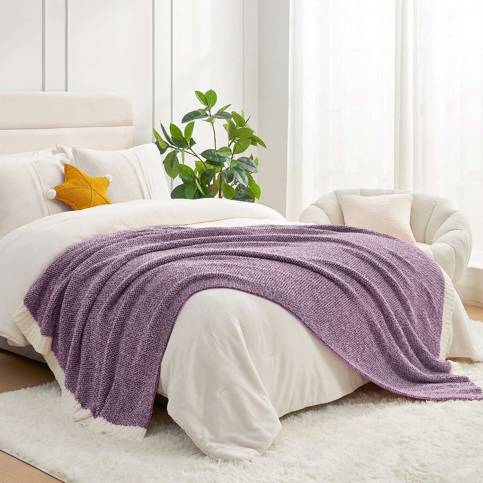 Bed with a purple blanket, white pillows, and a plant in a bright room. #color_Heather Purple