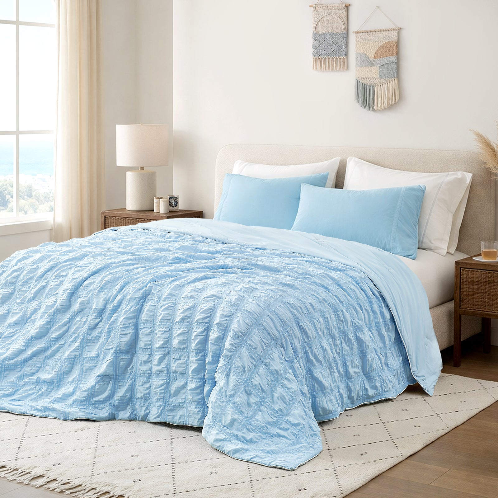 Snuggle Sac Cooling comforter in blue on bed in a bedroom with window,plant and a view behind#color_Blue