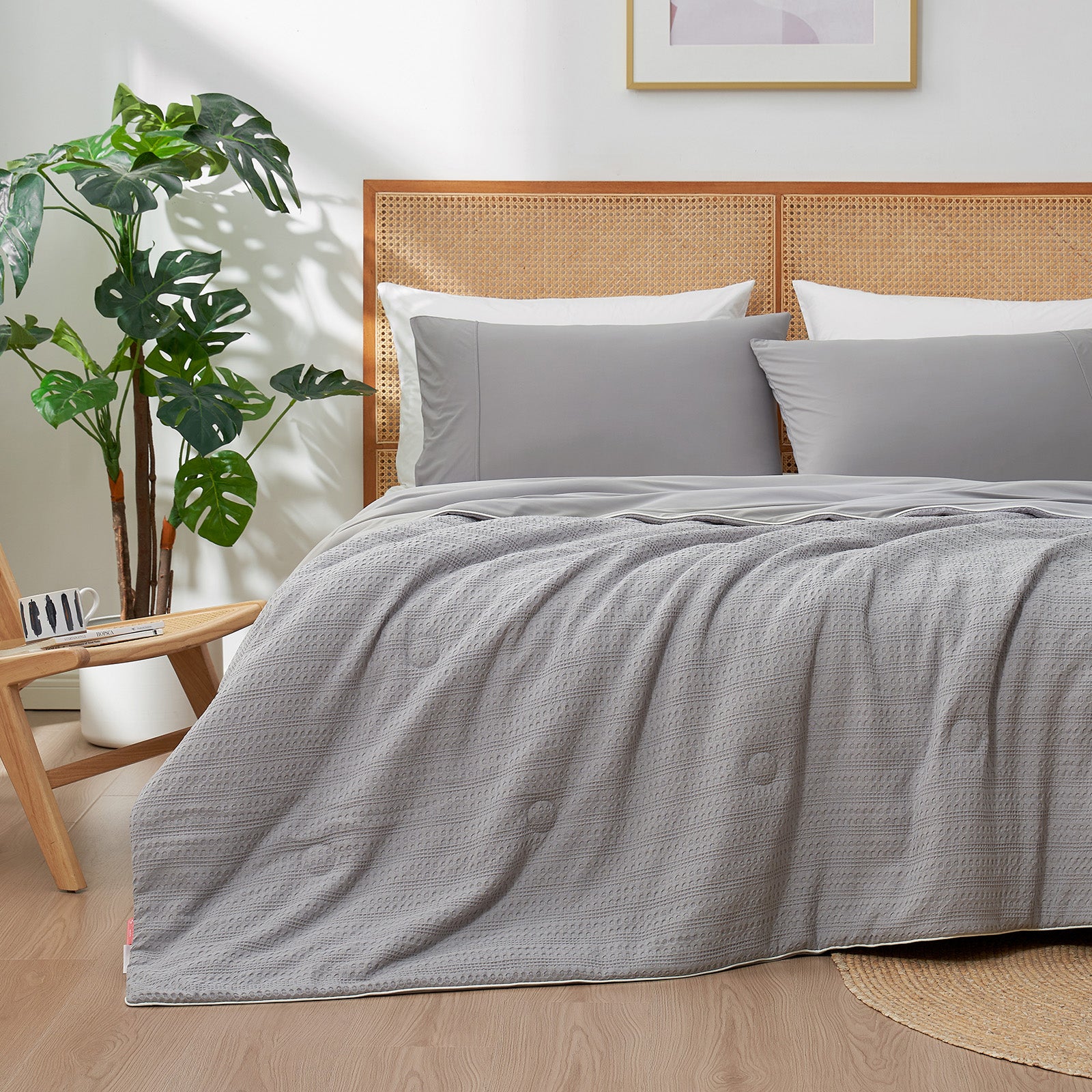Snuggle Sac Cooling comforter in grey on bed in a bedroom with plants#color_Grey
