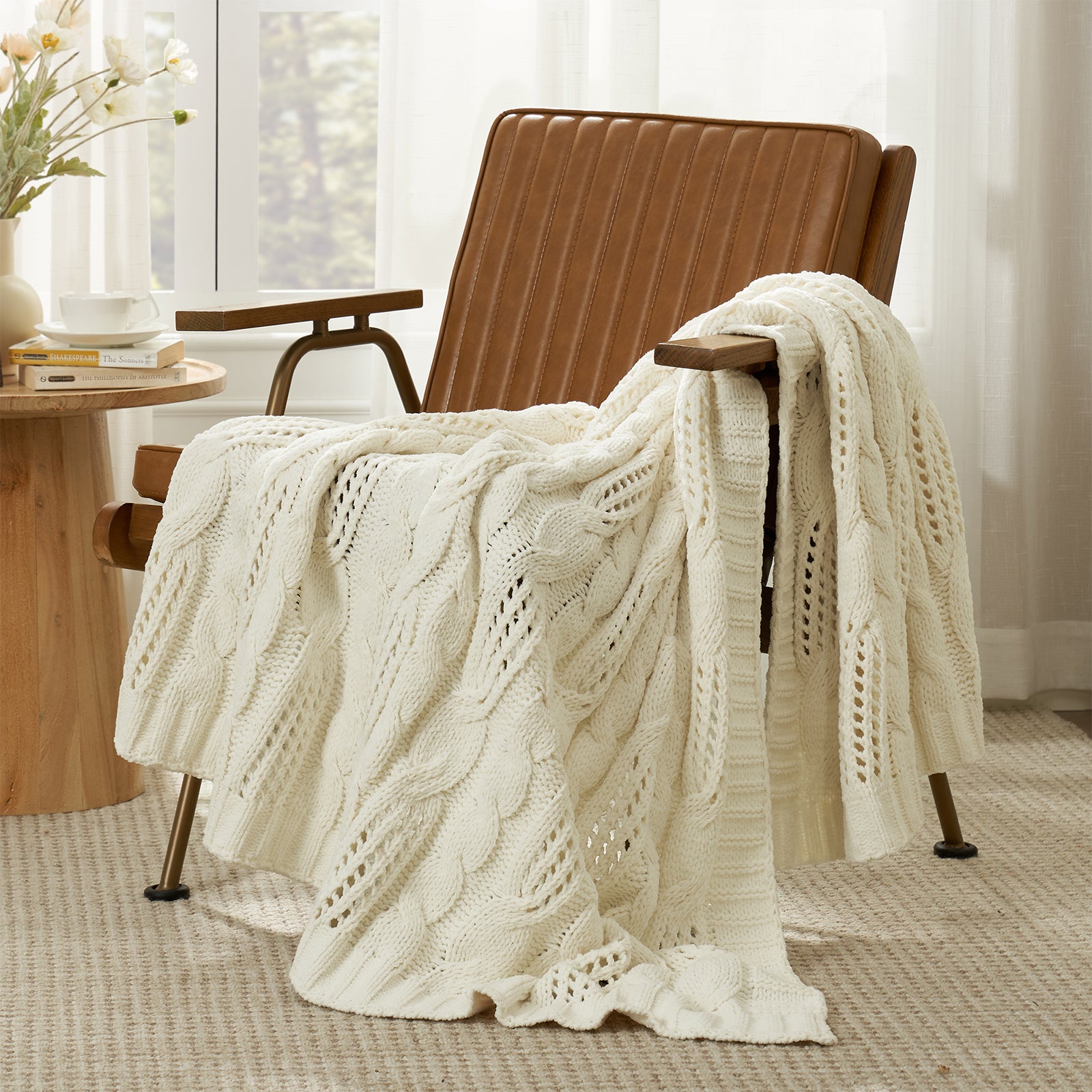 Snuggle Sac cable chenille knit throw blanket in Ivory draped over a chair creating a cozy corner #color_Ivory