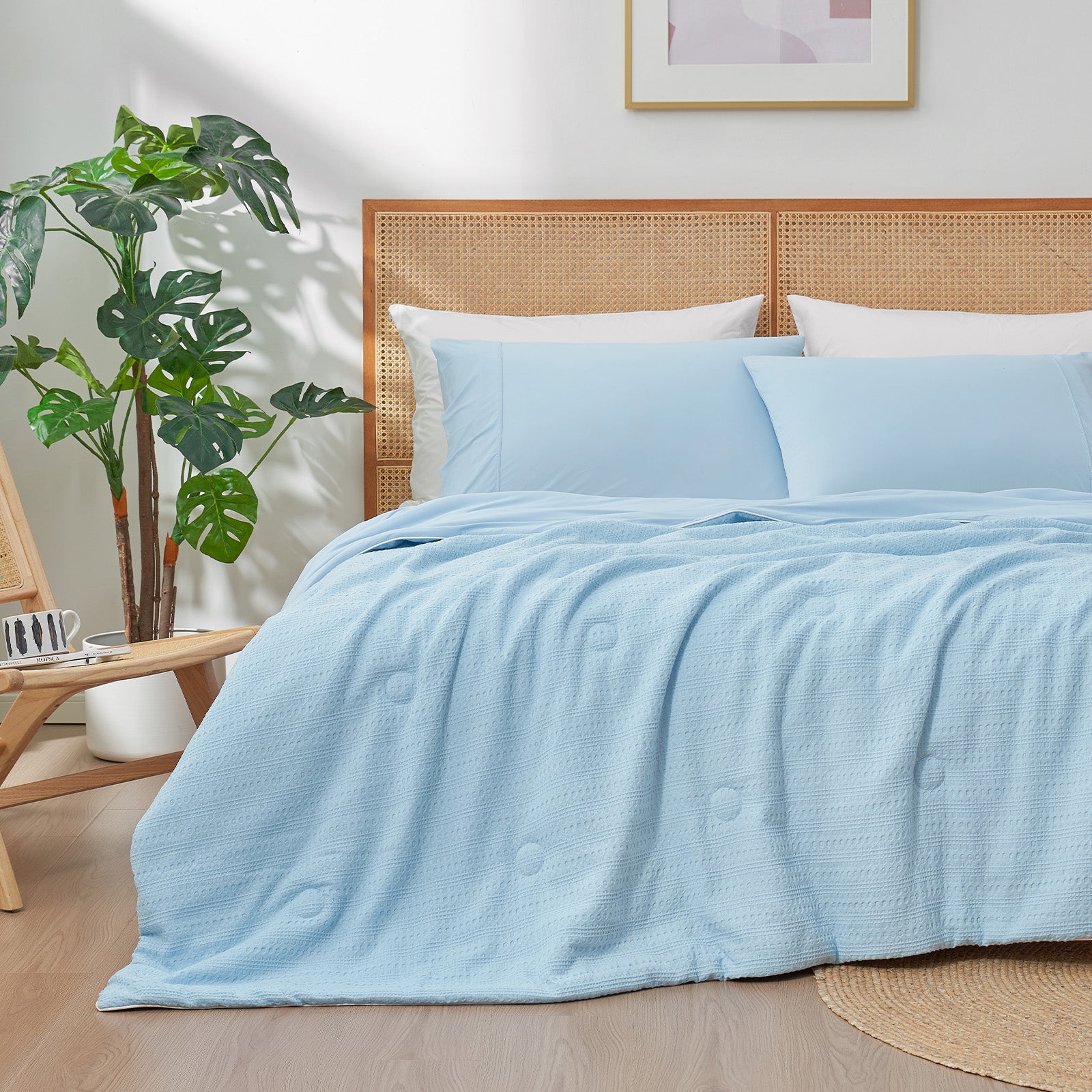 Snuggle Sac Cooling comforter in blue on bed in a bedroom with plants#color_Blue