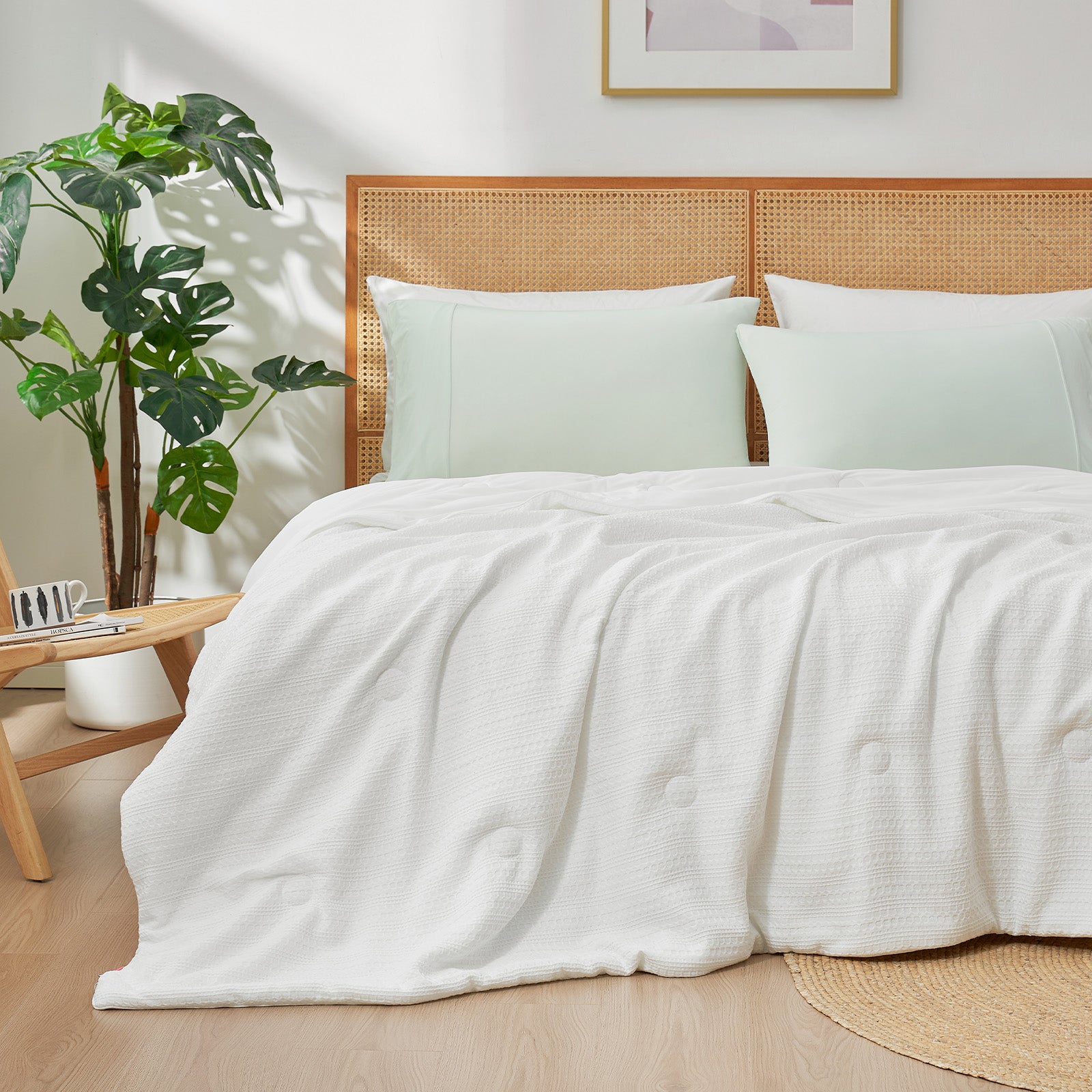 Snuggle Sac Cooling comforter in white on bed in a bedroom with plants#color_White