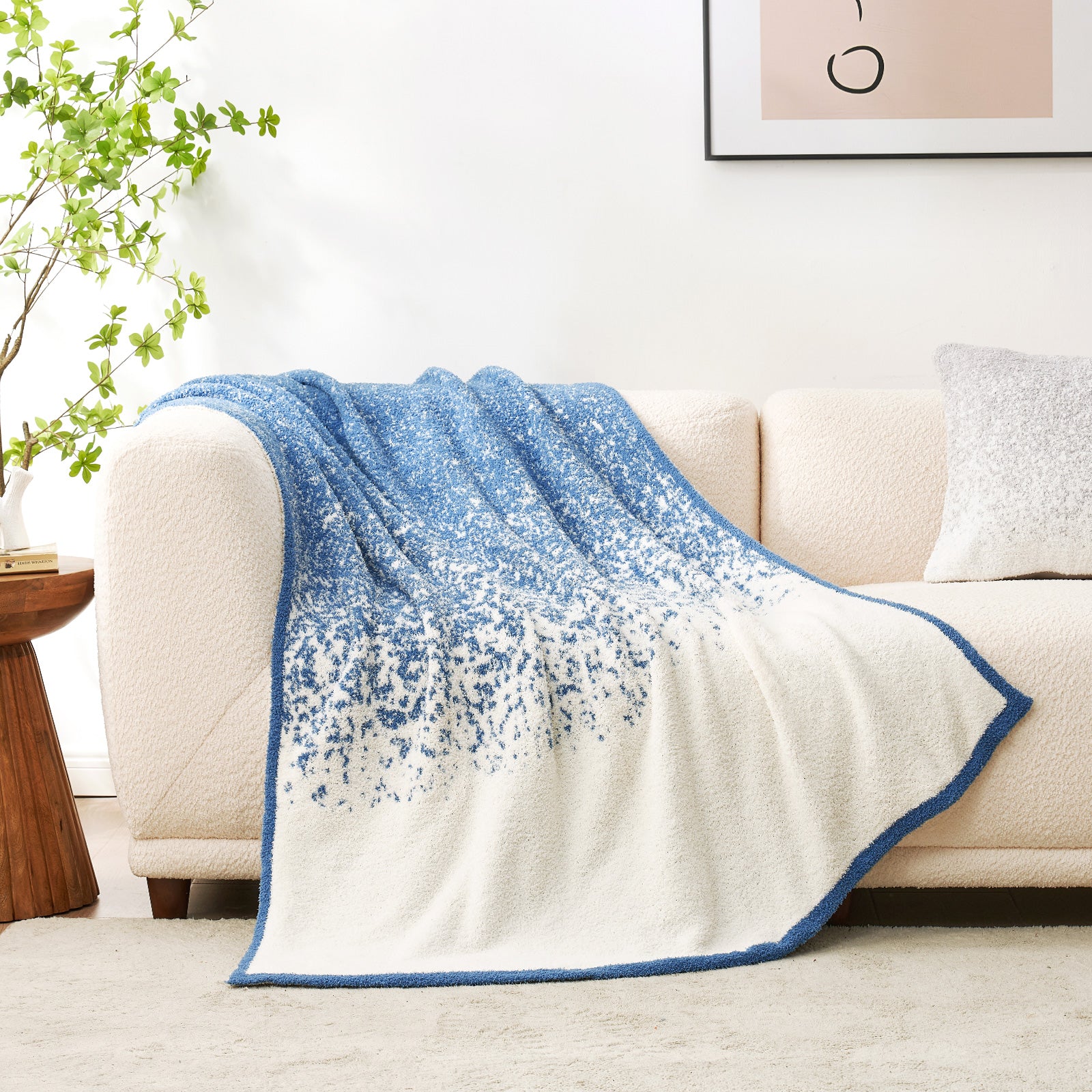 Reversed side Snuggle Sacs Reversible Ombre Heather Feather Yarn Knit Throw Blanket on a beige couch #color_Blue