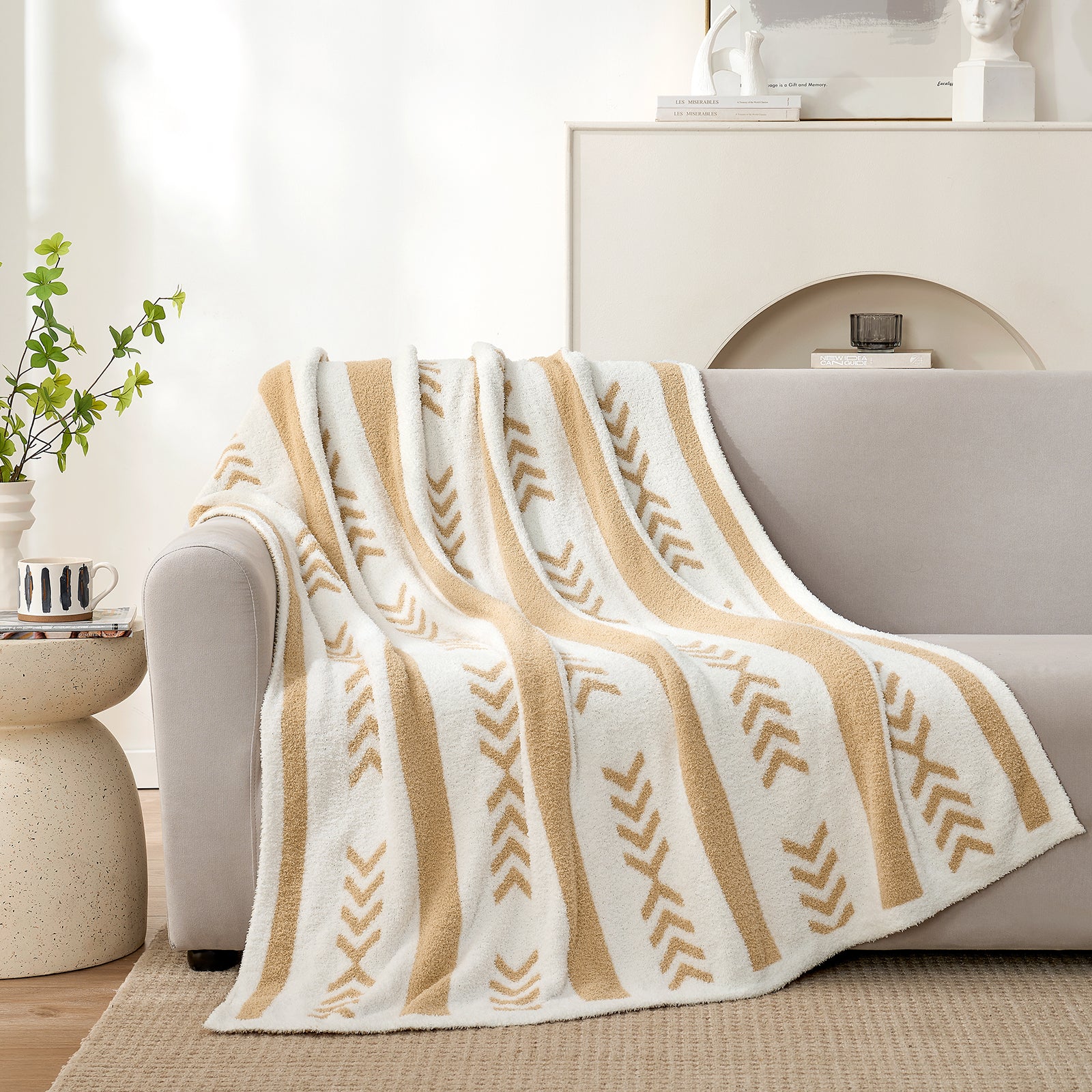 Snuggle Sacs Reversible Boho Feather Yarn Knit Throw Blanket draped on a grey couch#color_beige