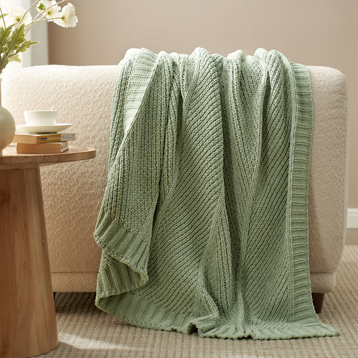 Snuggle Sac chevron chenille knit throw blanket in Sage Green draped over a sofa creating a warm and inviting look #color_Sage Green