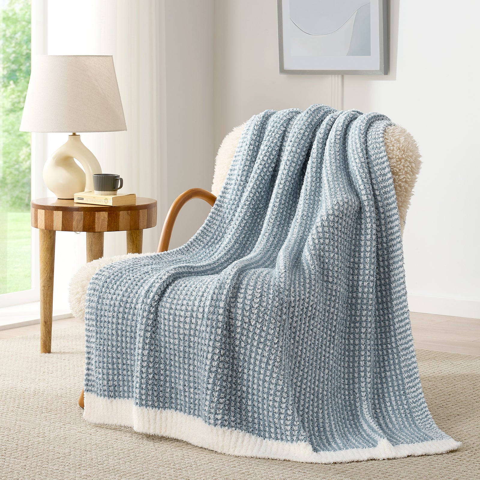 Soft Waffle Feather Yarn Knit Throw Blanket draped on a white sofa with plant and mug#color_Cream/Blue