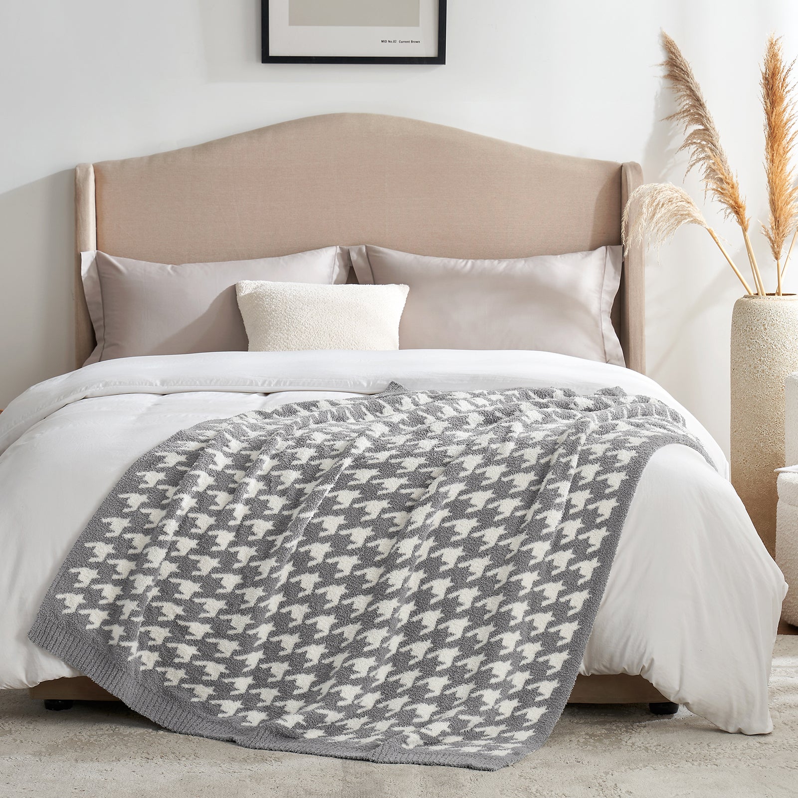 Bed with beige headboard, white bedding, and gray patterned throw blanket in a bedroom setting.#color_Grey
