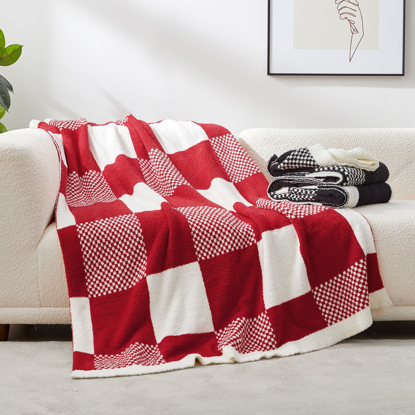 Red and white checkered blanket draped over a beige sofa with a plant and framed picture in the background. #color_Red White