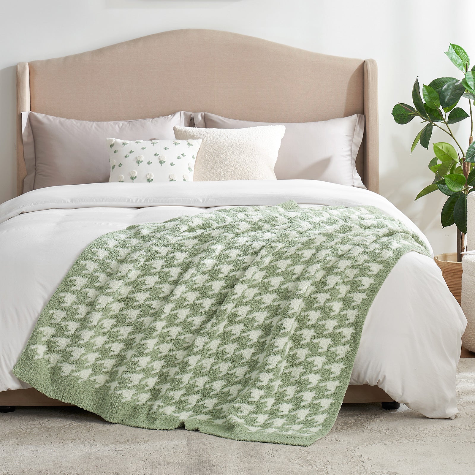Bed with a green and white patterned blanket, beige headboard, and white pillows. #Color_Sage Green