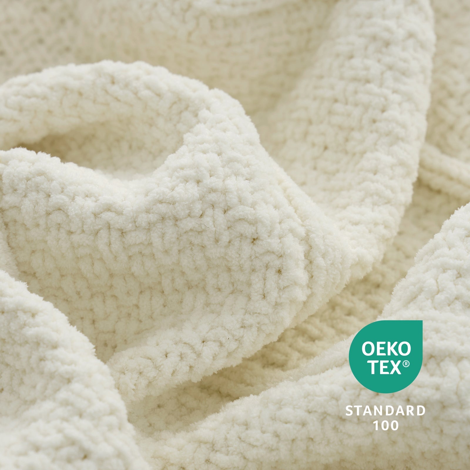 Close-up of textured fabric blanket in Ivory with Oeko-Tex Standard 100 logo. #color_Ivory