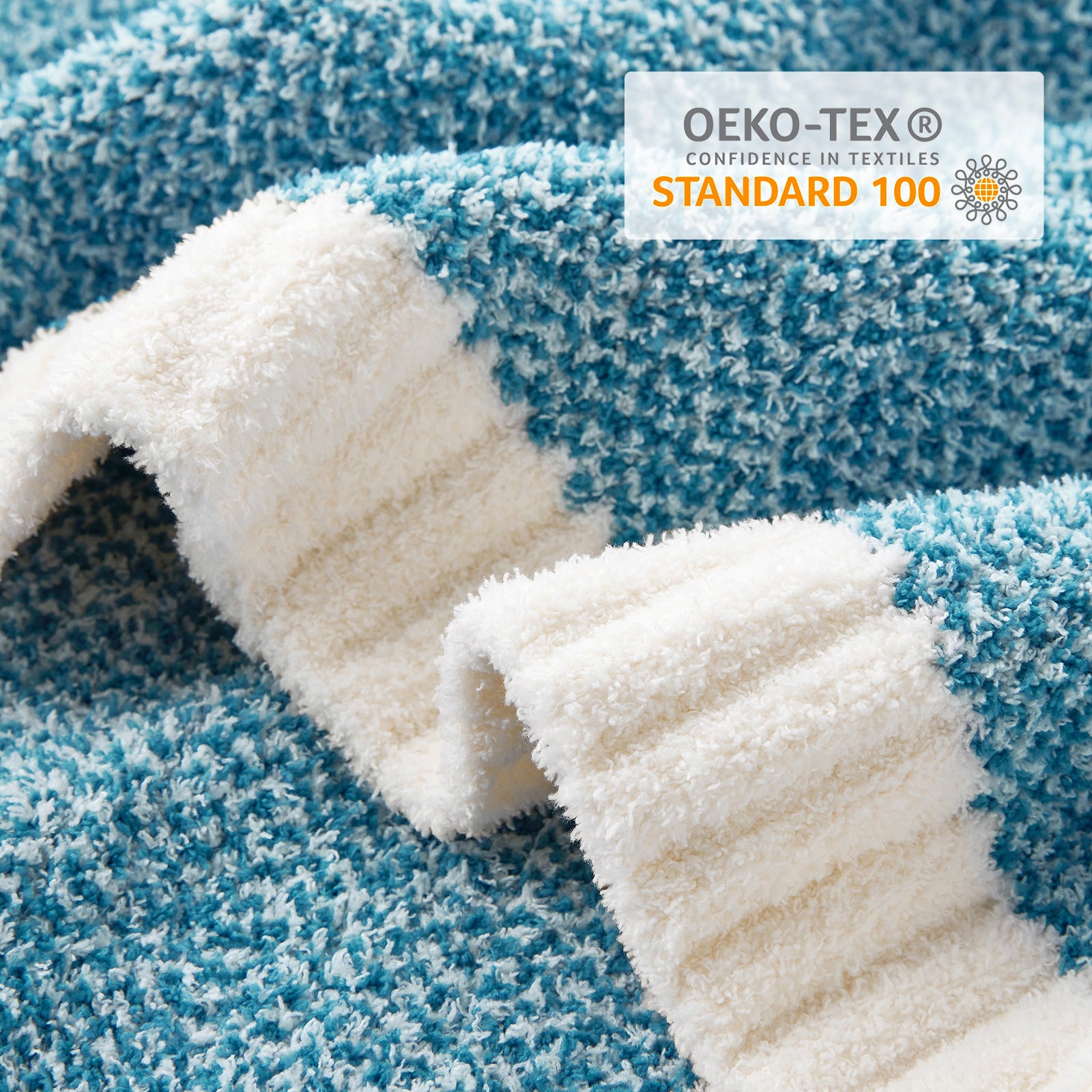 Close-up of blue and white textured fabric with OEKO-TEX Standard 100 logo. #color_Heather Teal