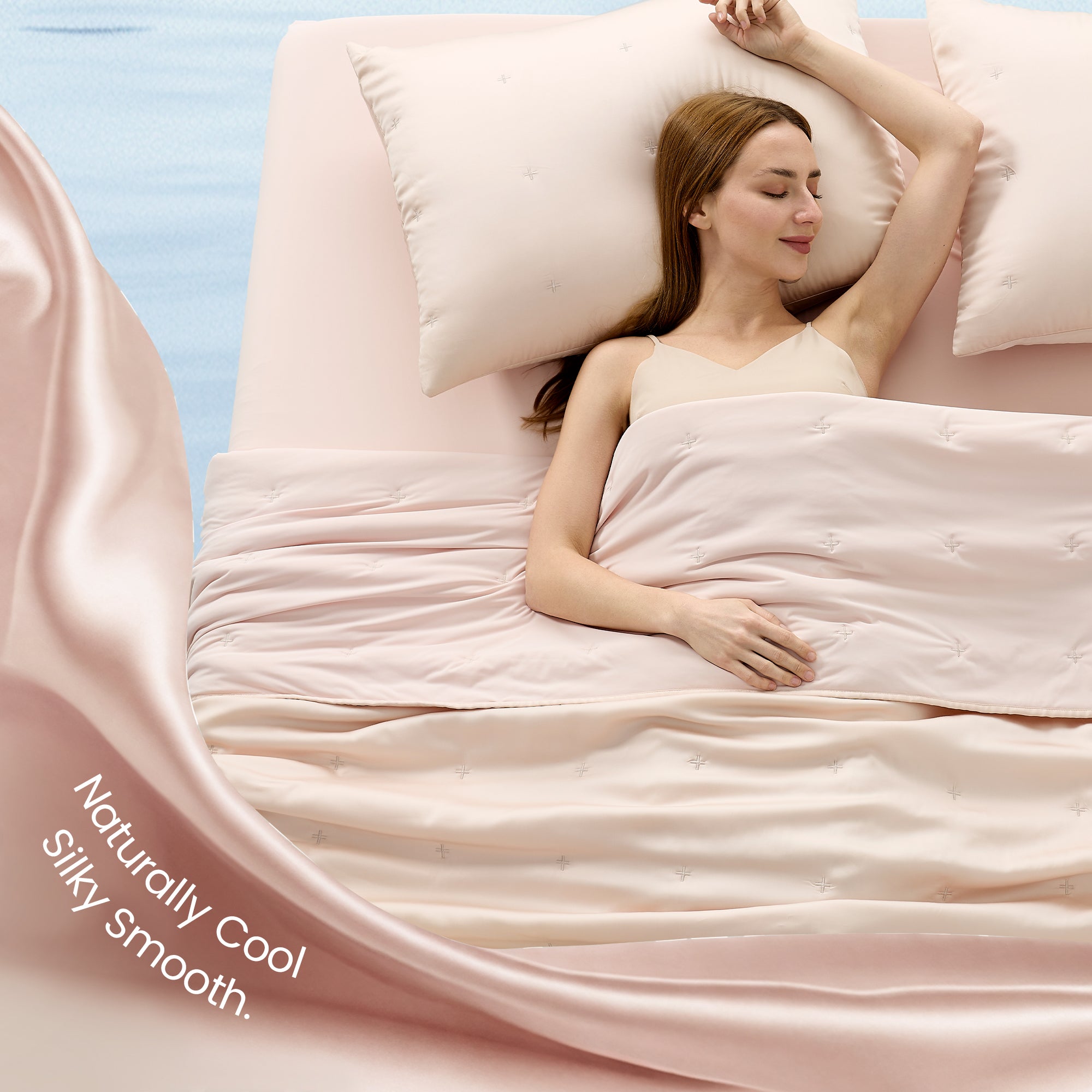 A woman laying down on the bed with Snuggle Sac Cooling comforter showing naturally cool and silky smooth#color_Champagne