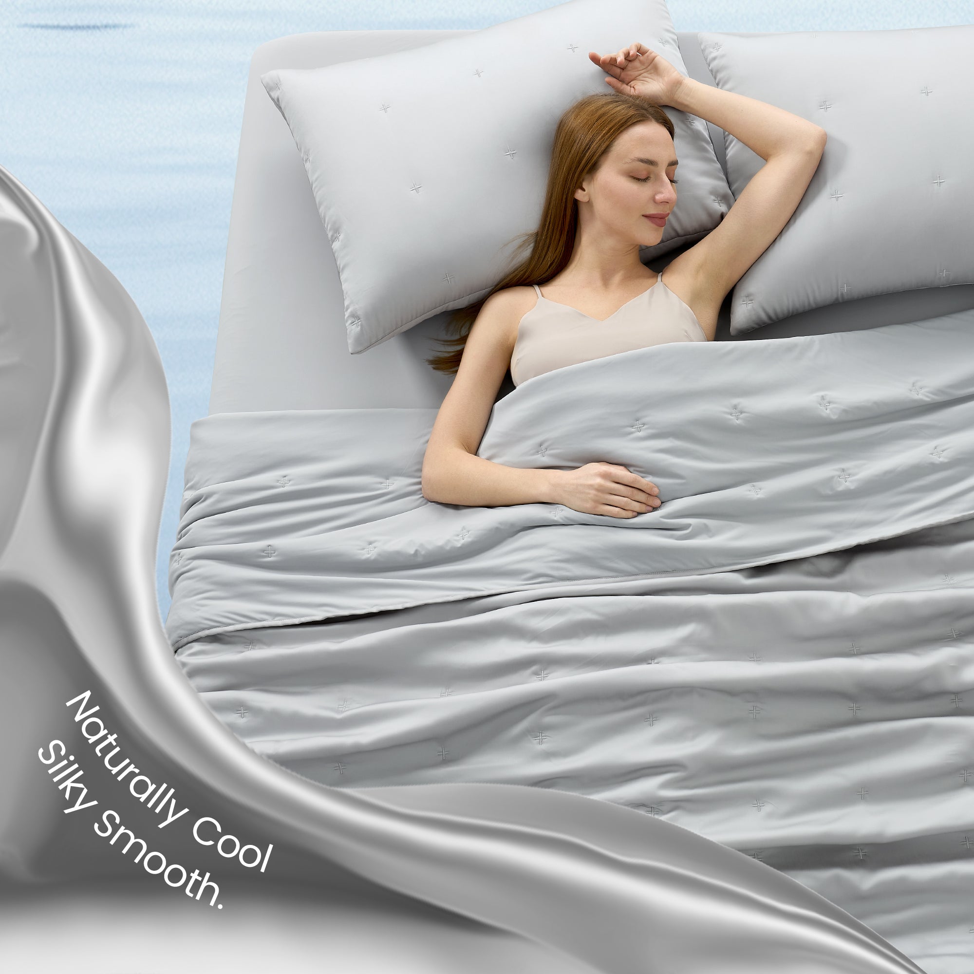 A woman laying down on the bed with Snuggle Sac Cooling comforter#color_Grey