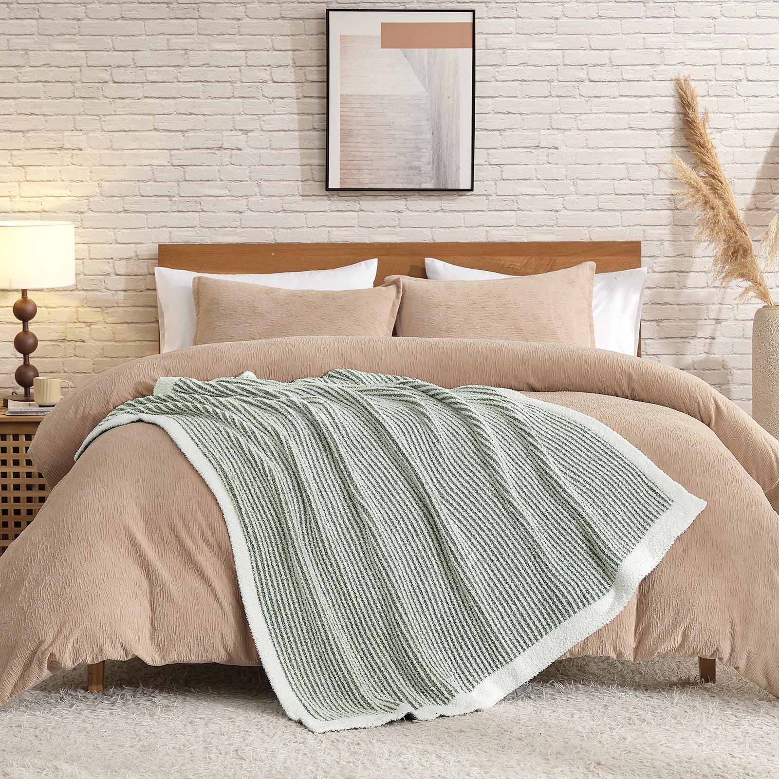 Beige comforter set on a bed with a striped green throw blanket, against a brick wall. #color_Green/Cream