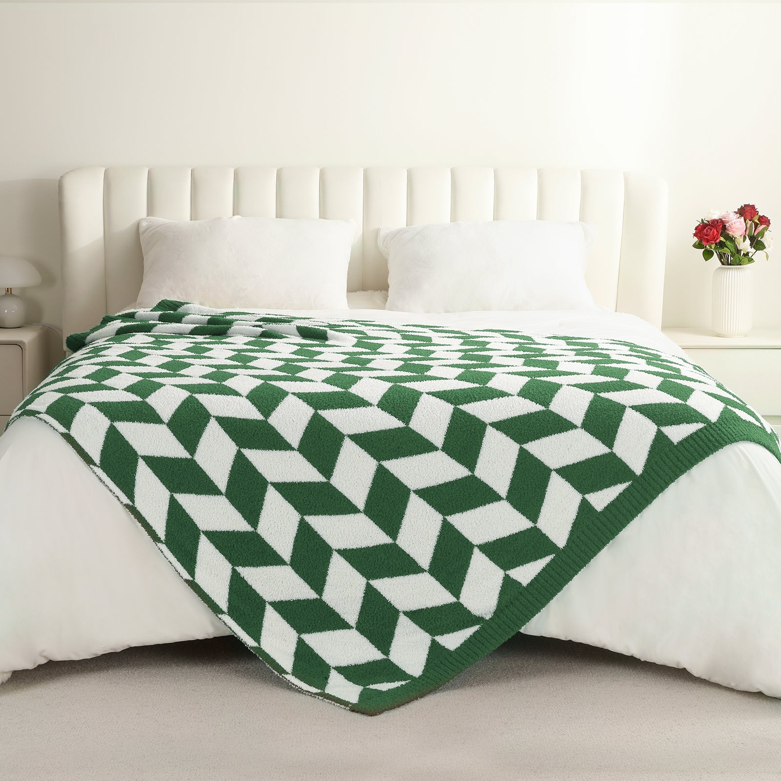 Green and white geometric patterned blanket on a bed with a white headboard. #color_ Xmas Green
