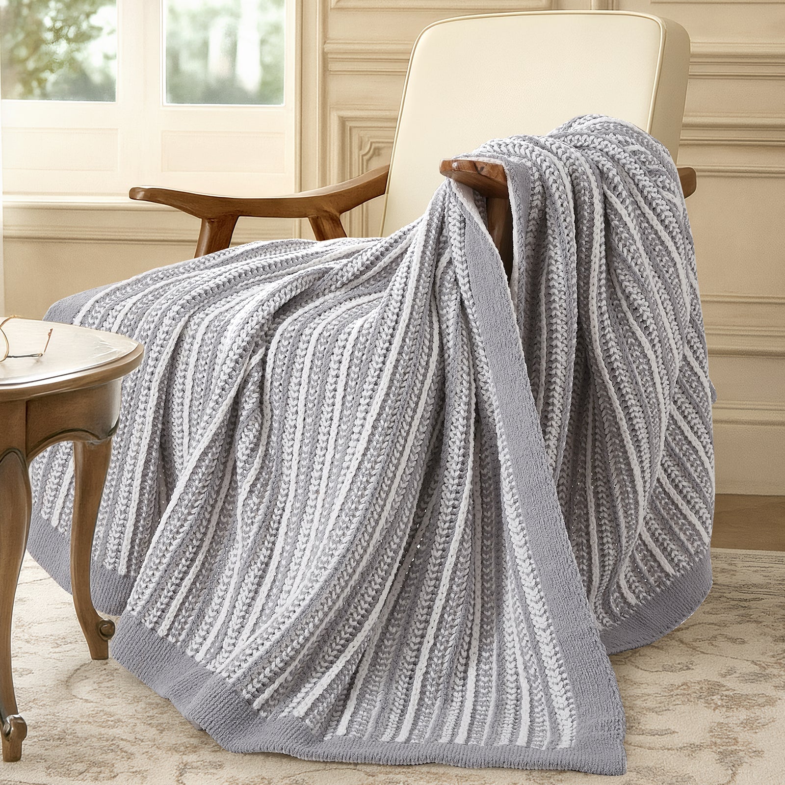 Gray textured blanket draped over a chair in a room with a window and table. #color_Gray&White