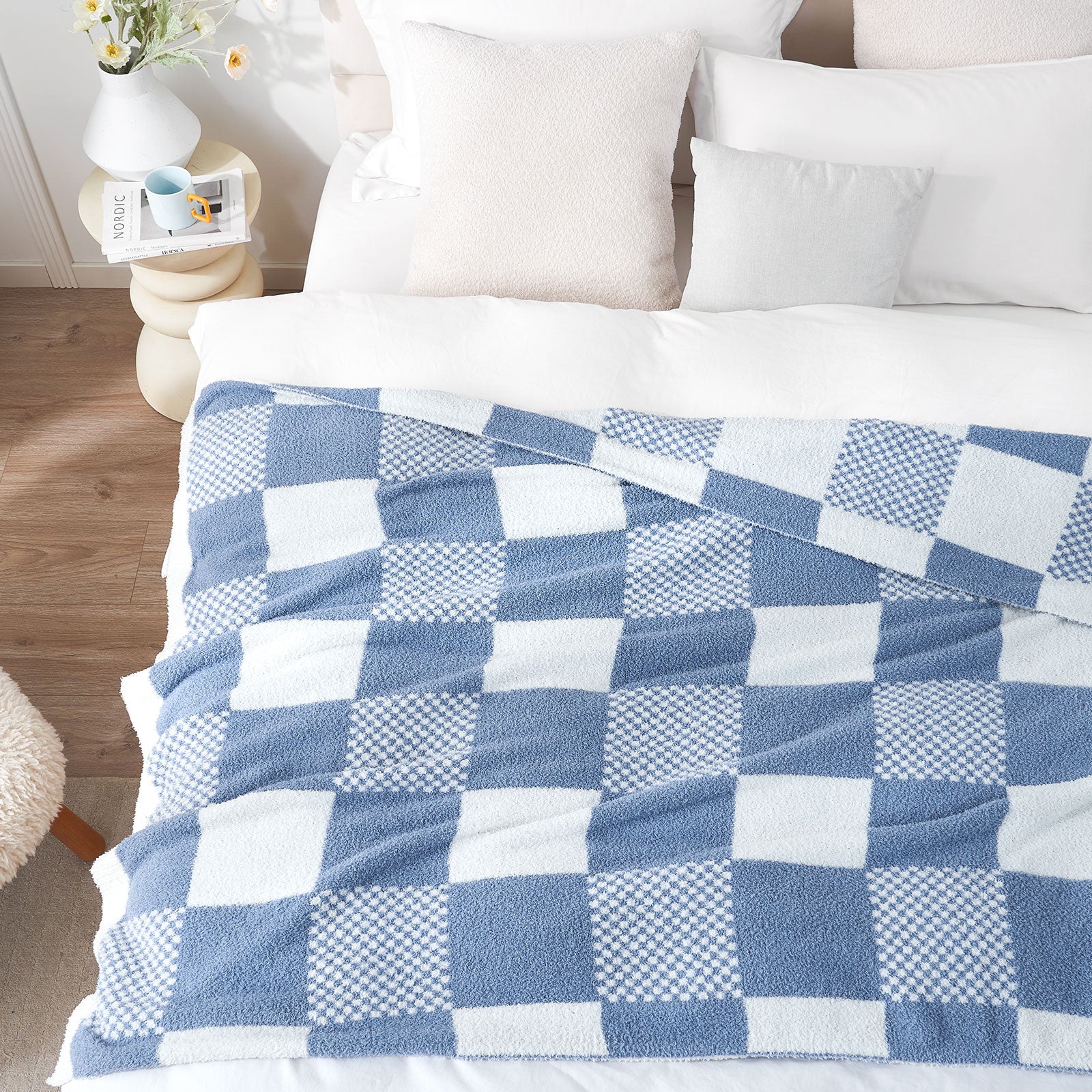 Blue and white checkered blanket on a bed with pillows and a wooden nightstand.#color_Pale Blue