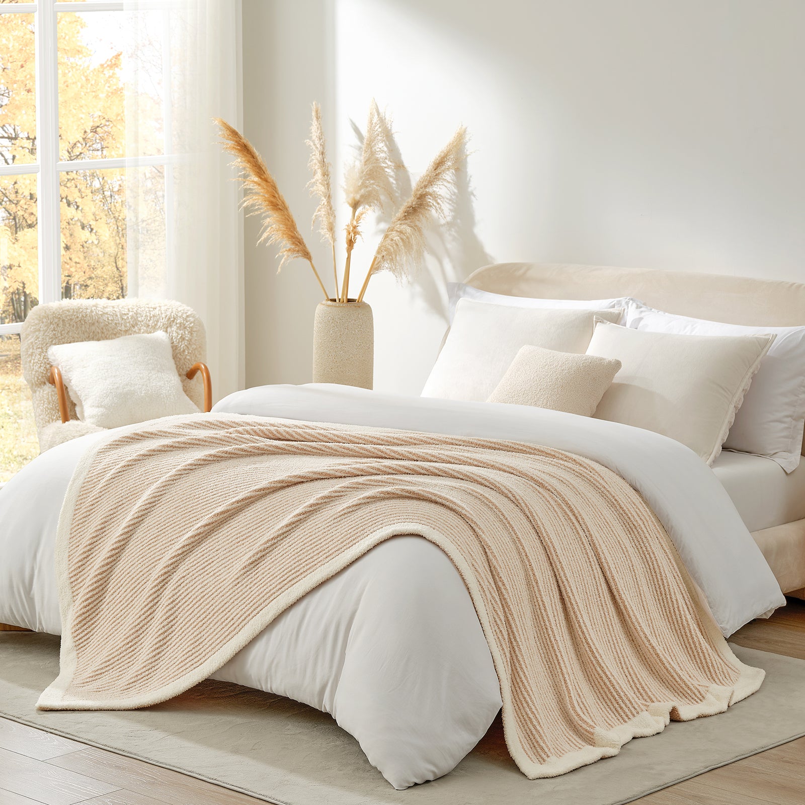 Beige knitted blanket on a bed in a bright bedroom with natural light #color_Cream/Beige