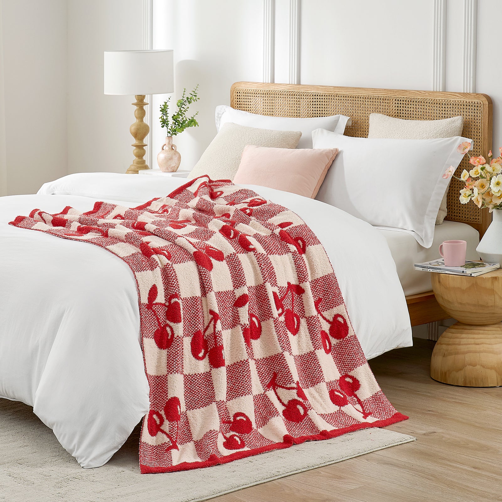 Snuggle Sacs Red Cherry Feather Yarn Knit Throw Blanket on the bed in a bright room with vases of flowers and plant#color_Red_Cherry