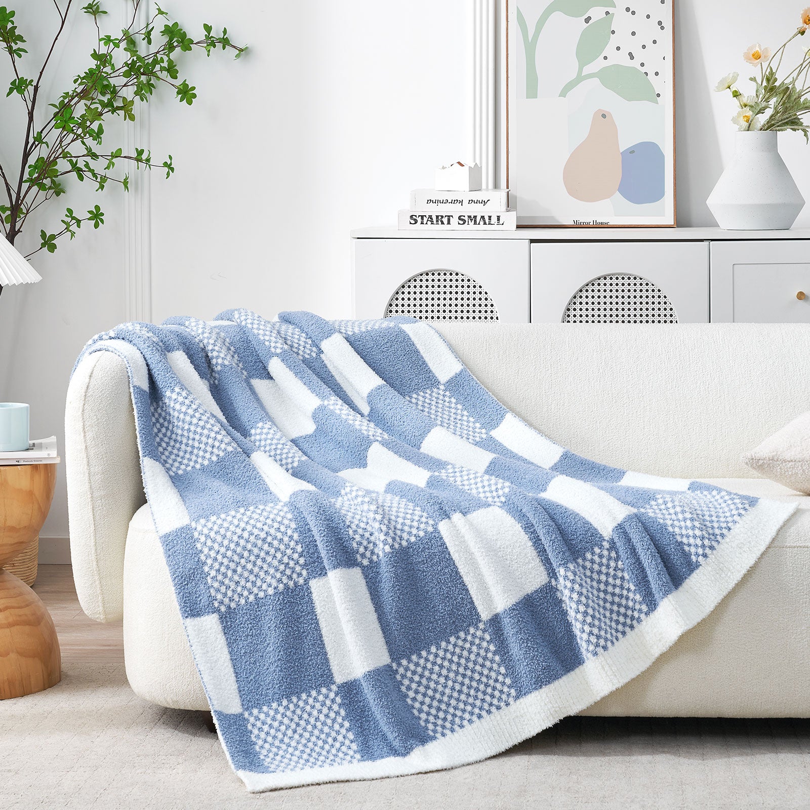 Blue and white checkered blanket draped over a sofa in a living room setting. #color_Washed Blue