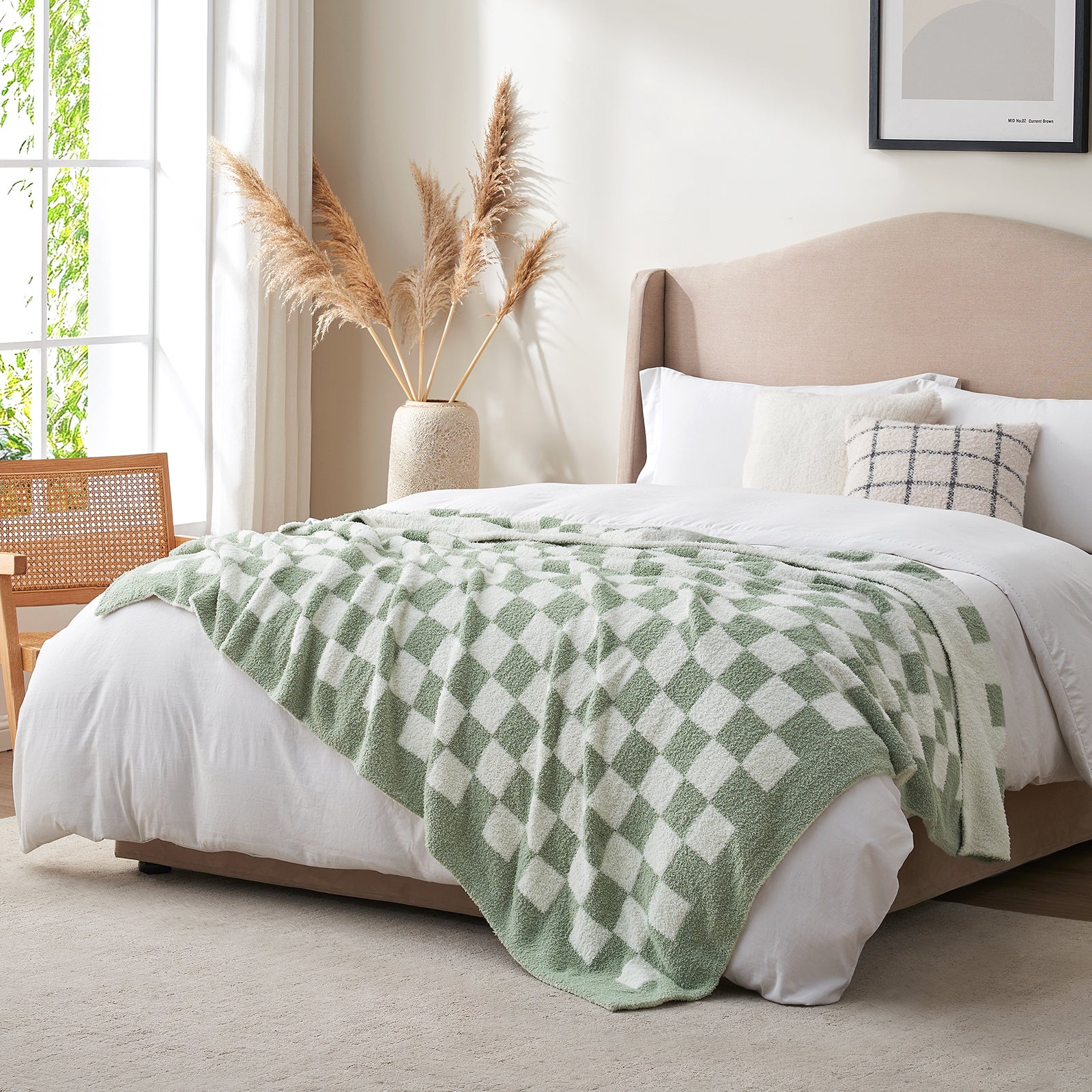 Bedroom with a bed featuring a green and white checkered blanket, pillows, and a vase with dried plants. #color_Checkered Sage Green