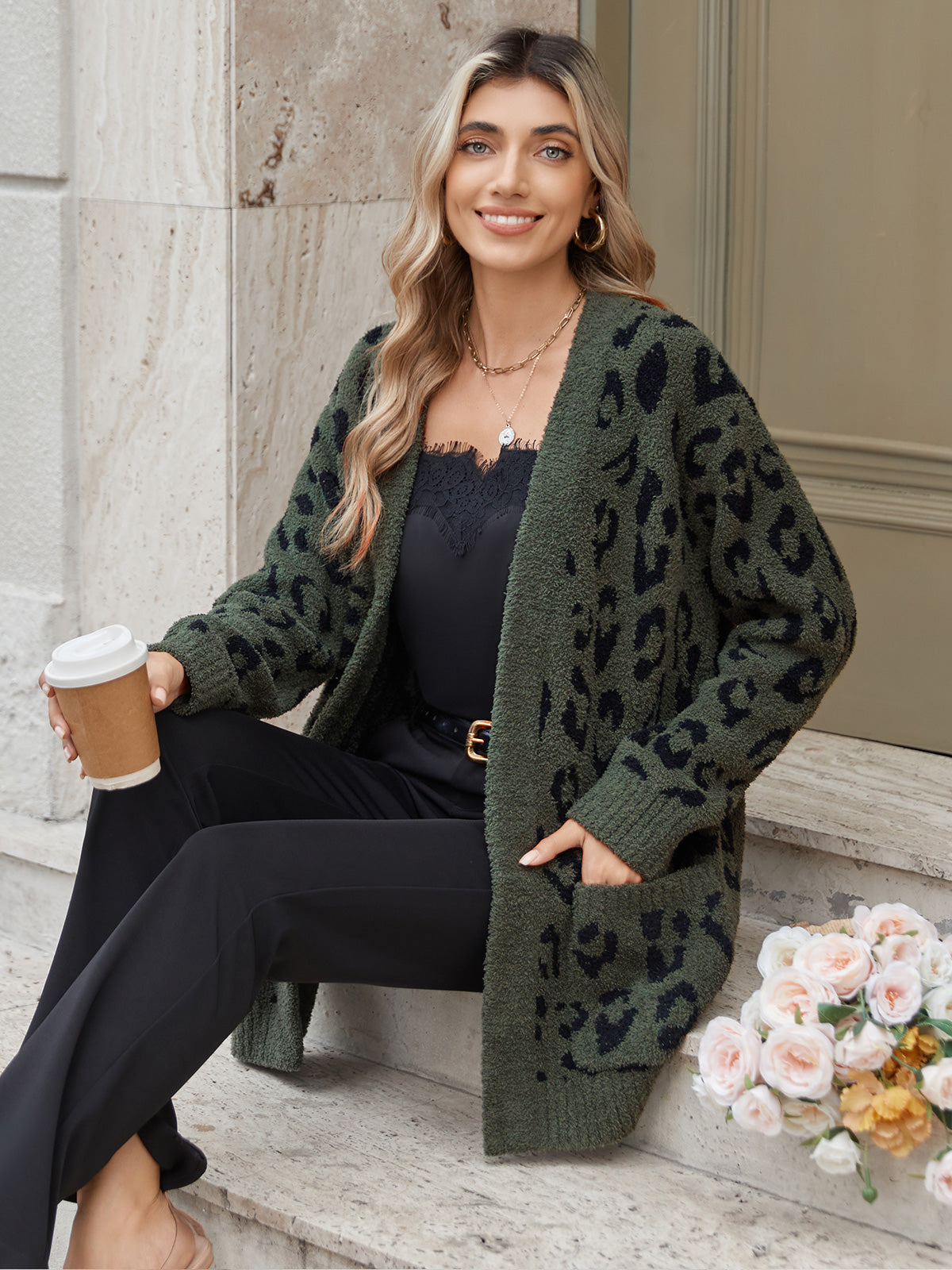 Woman wearing a green leopard print cardigan sitting on steps with a coffee cup and flowers. #color_Leopard Army Green