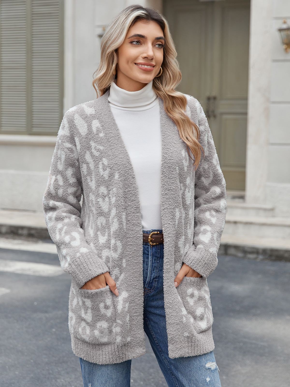 Woman wearing a gray patterned cardigan over a white turtleneck and blue jeans, standing on a street. #color_Leopard Grey