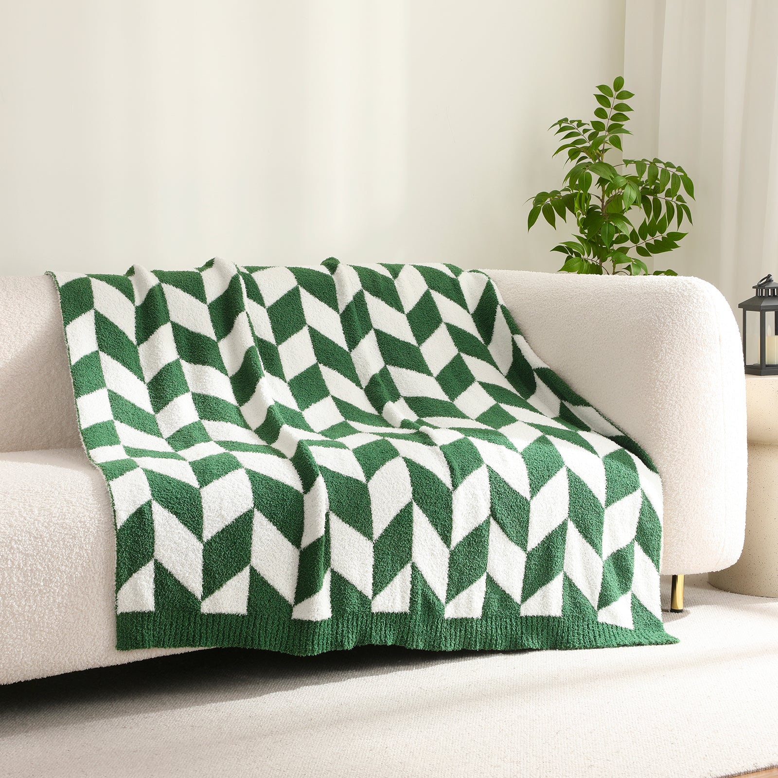 Green and white chevron patterned blanket on a beige sofa with a plant in the background #color_ Xmas Green