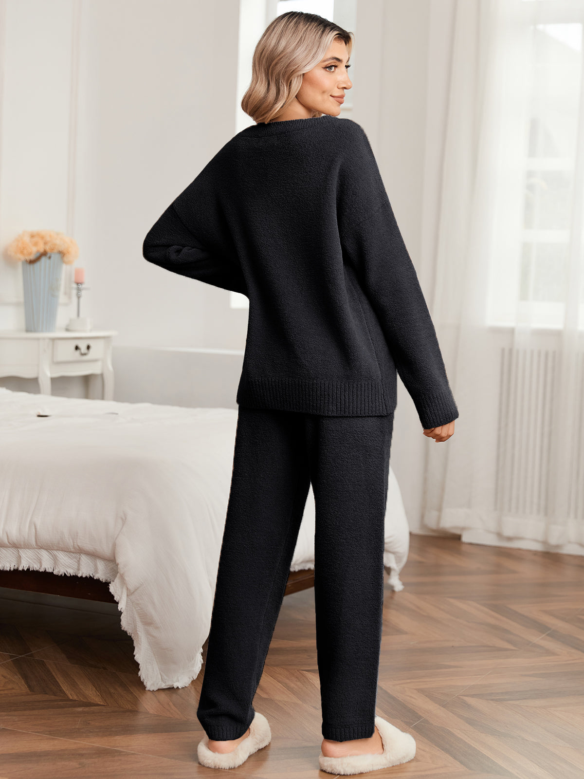 Woman wearing a black outfit in a bedroom setting #color_Black