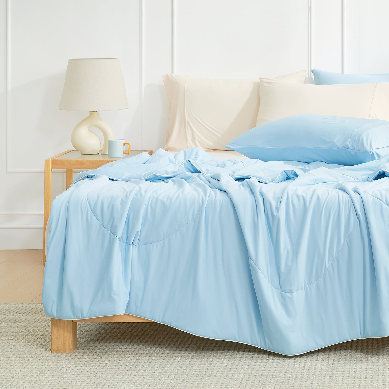 Bed with blue bedding in a bright bedroom setting#color_Sky Blue