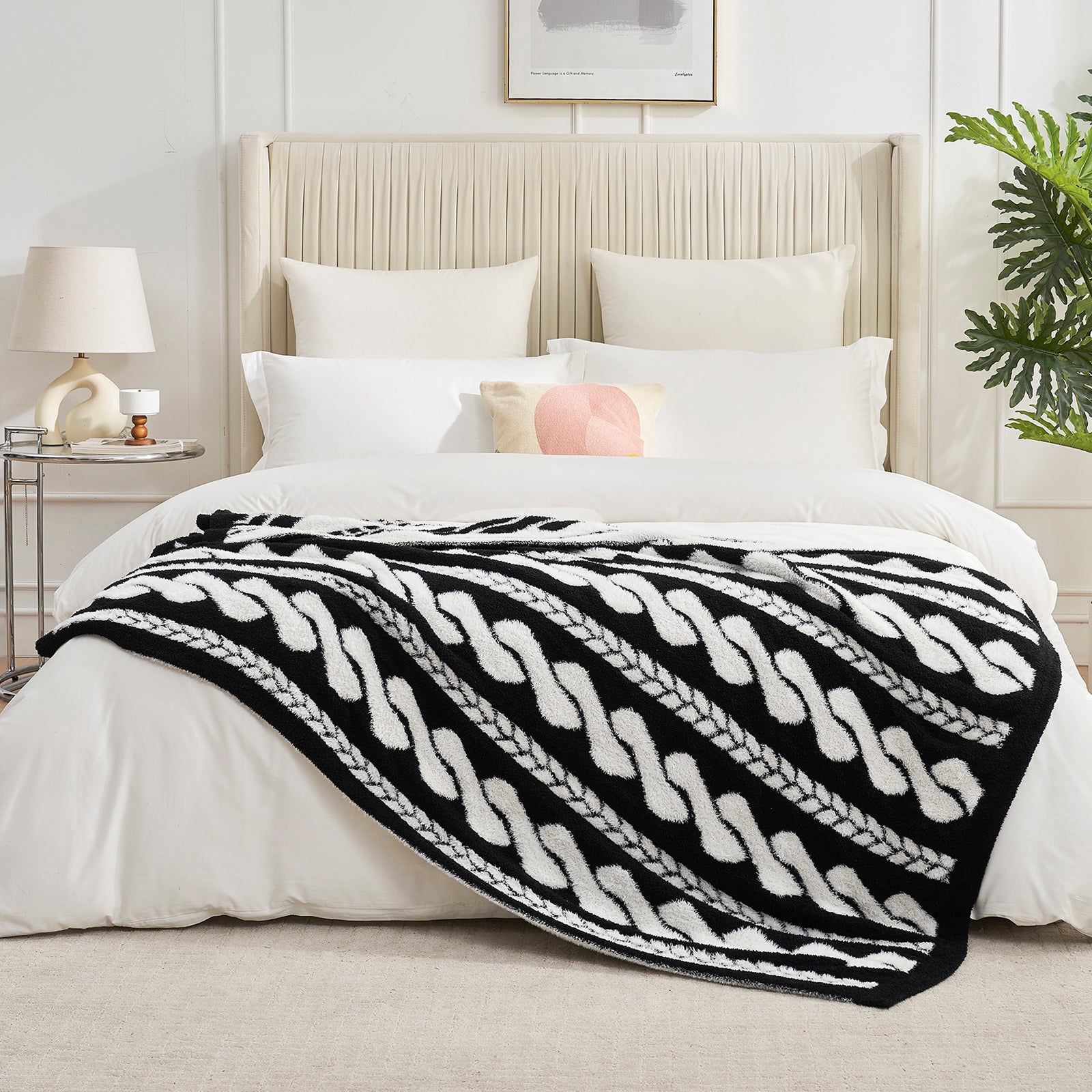Cable pattern Faux Fur Knit Throw Blanket in black and white on a bed in a bedroom setting.#color_Black