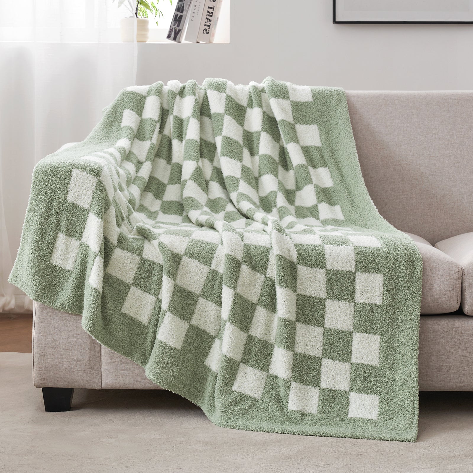 Green and white checkered blanket draped over a sofa in a living room. #color_Checkered Sage Green