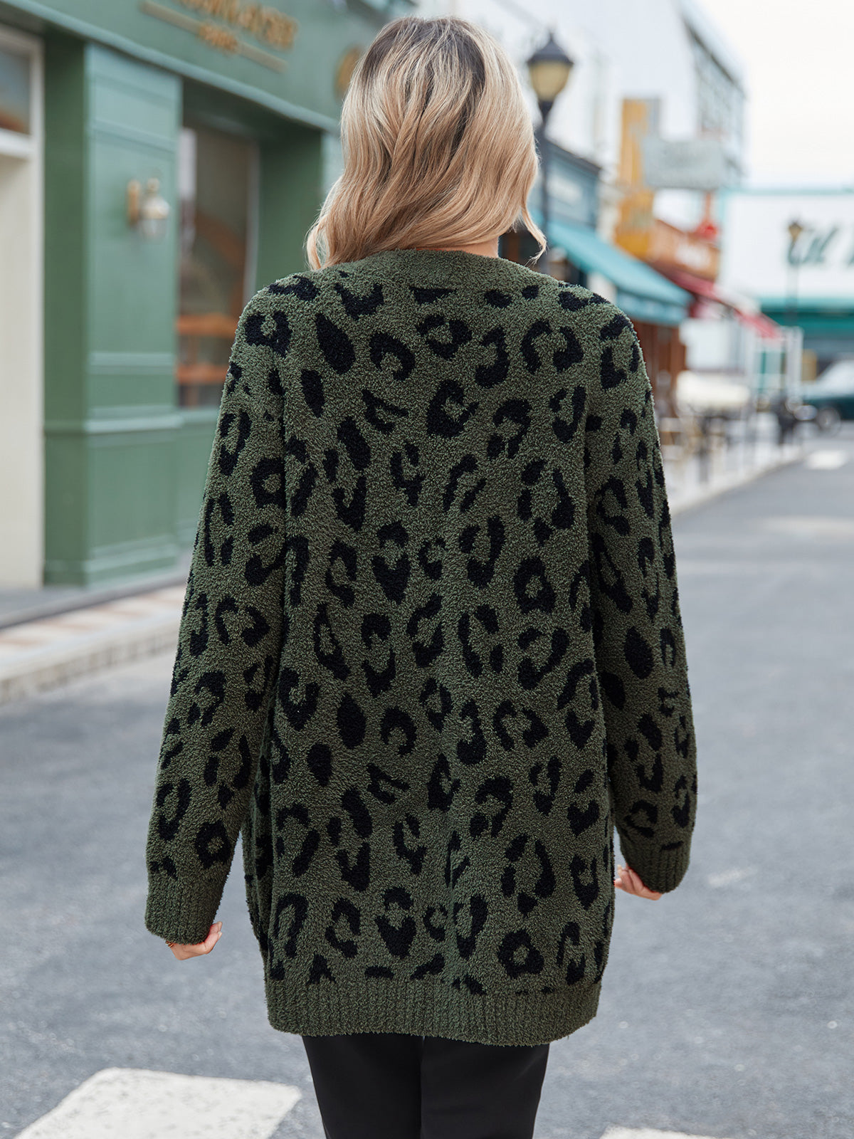 Person wearing a green leopard print cardigan on a city street. #color_Leopard Army Green