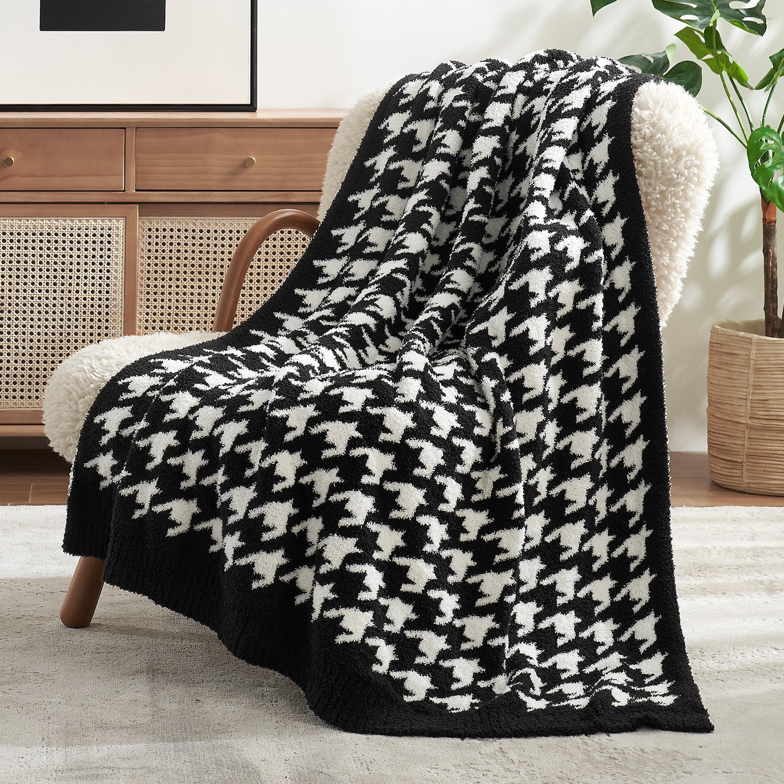 Black and white houndstooth patterned blanket draped over a chair in a living room setting. #color_Black