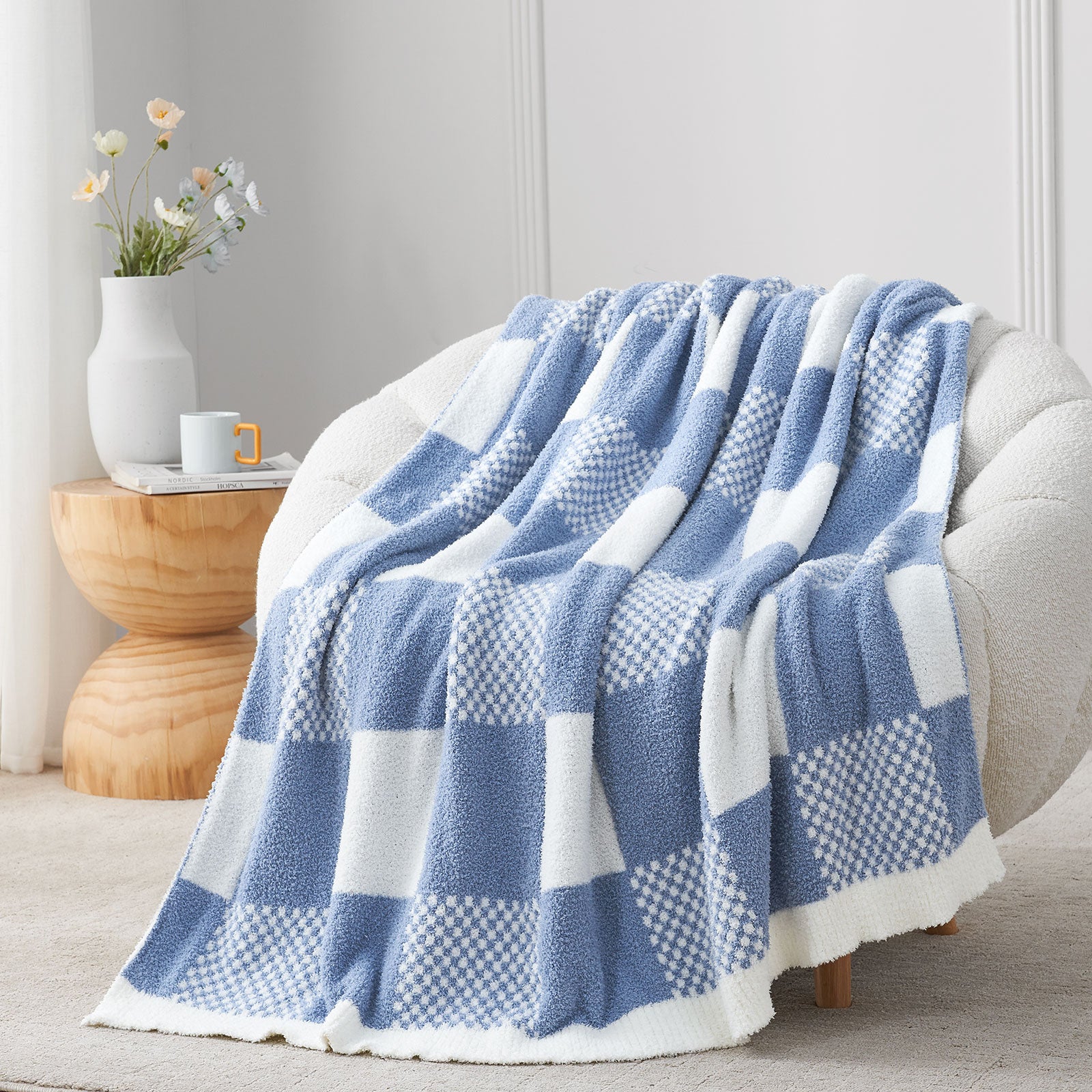 Blue and white checkered blanket draped over a chair in a cozy room. #color_Washed Blue