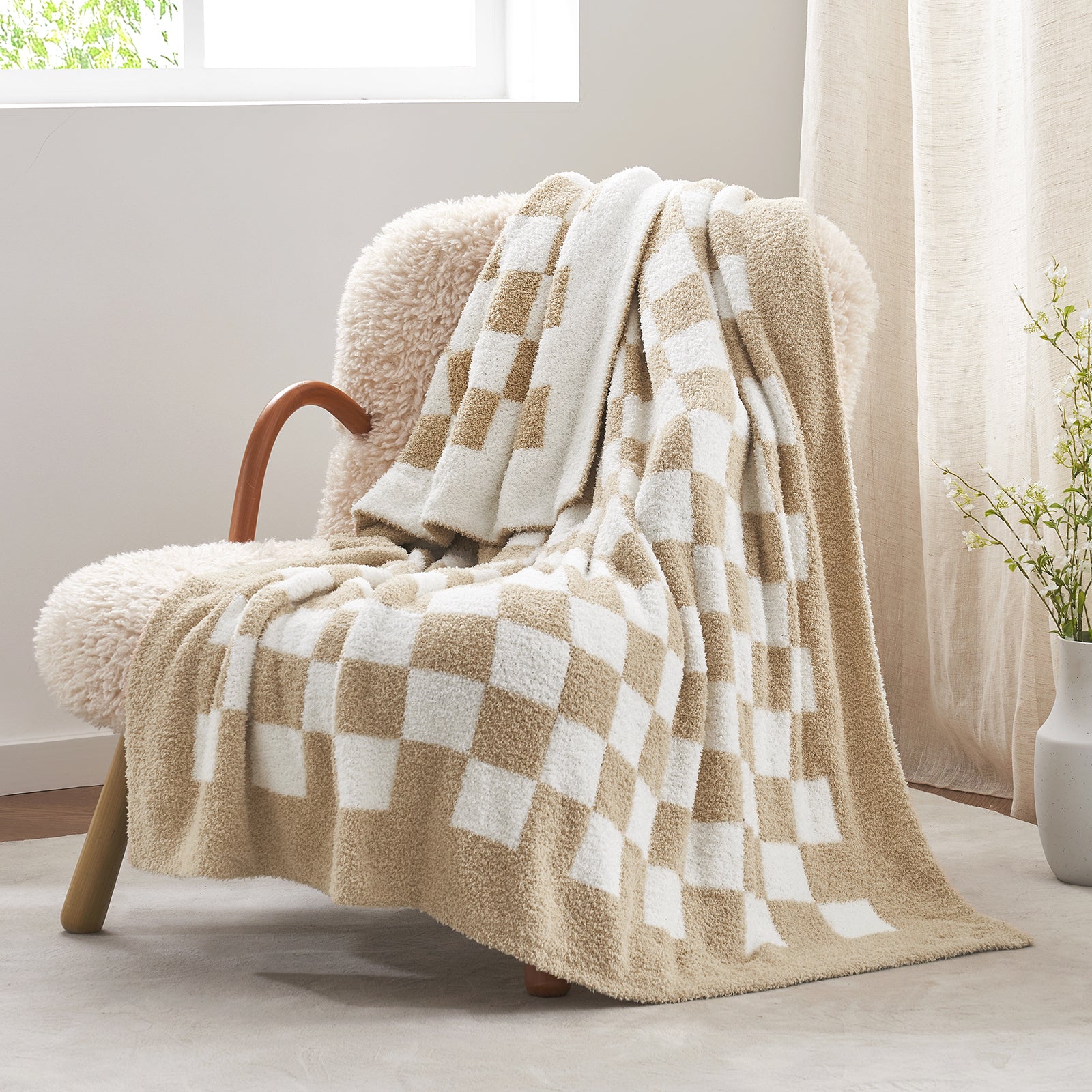 Checkered blanket draped over a chair in a bright room with natural light. #color_Checkered Beige