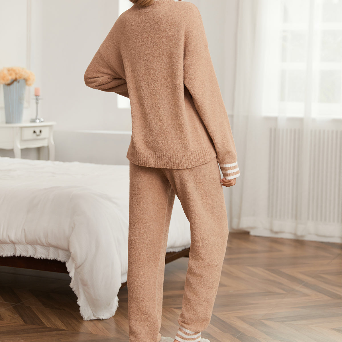 Woman wearing a beige lounge set in a cozy bedroom. #color_Khaki