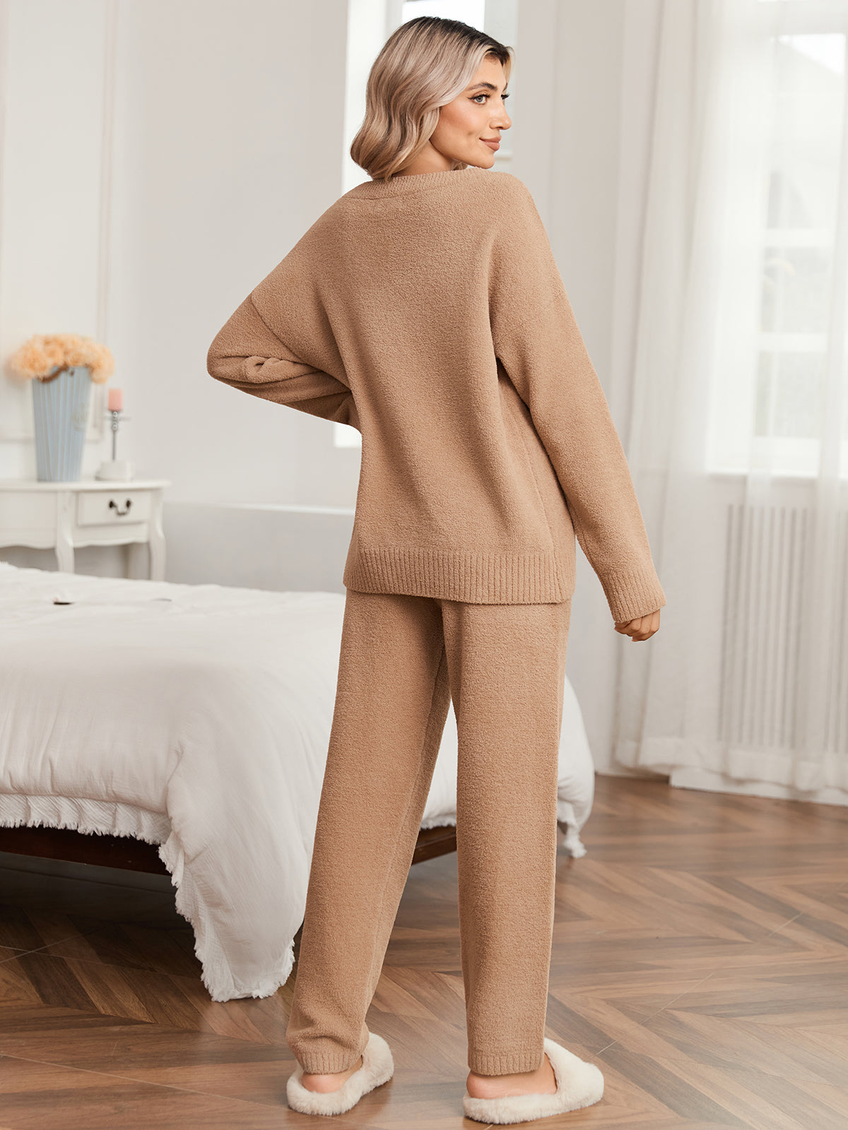 Woman wearing a beige sweater and pants set in a bedroom. #color_Khaki