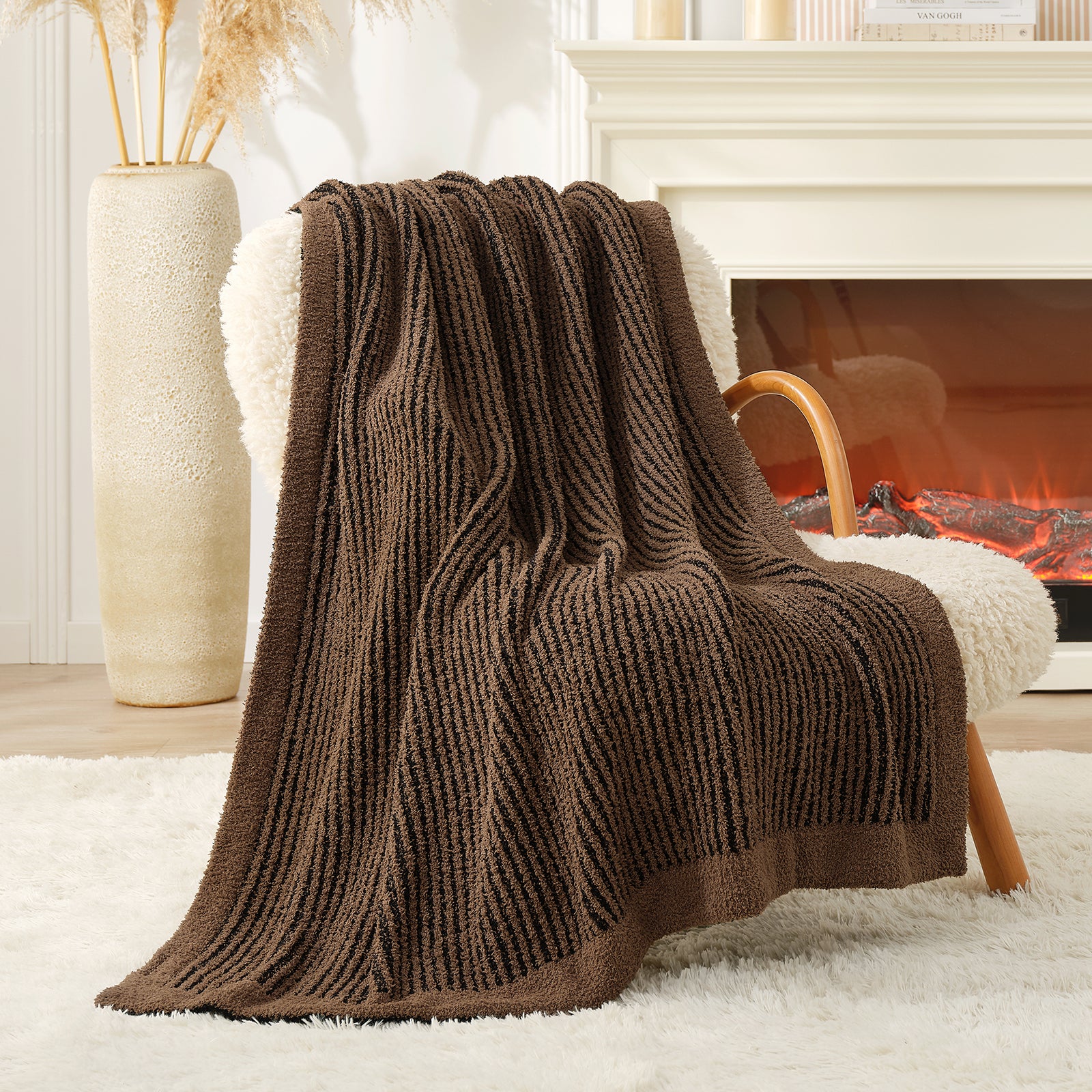 Brown textured blanket draped over a chair in front of a fireplace #color_Brown/Black