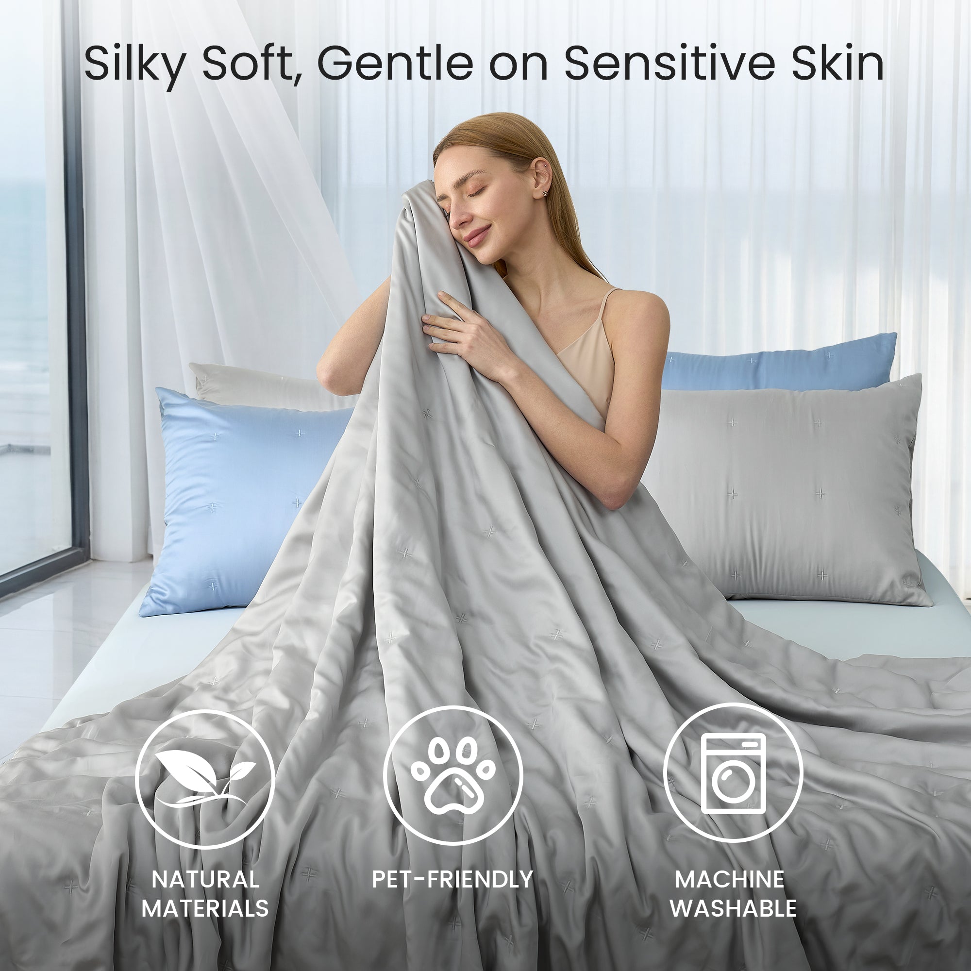 A woman wrapped in Snuggle Sac Cooling comforter sitting on the bed proving Silky Soft, Gentle on sensitive skin#color_Grey