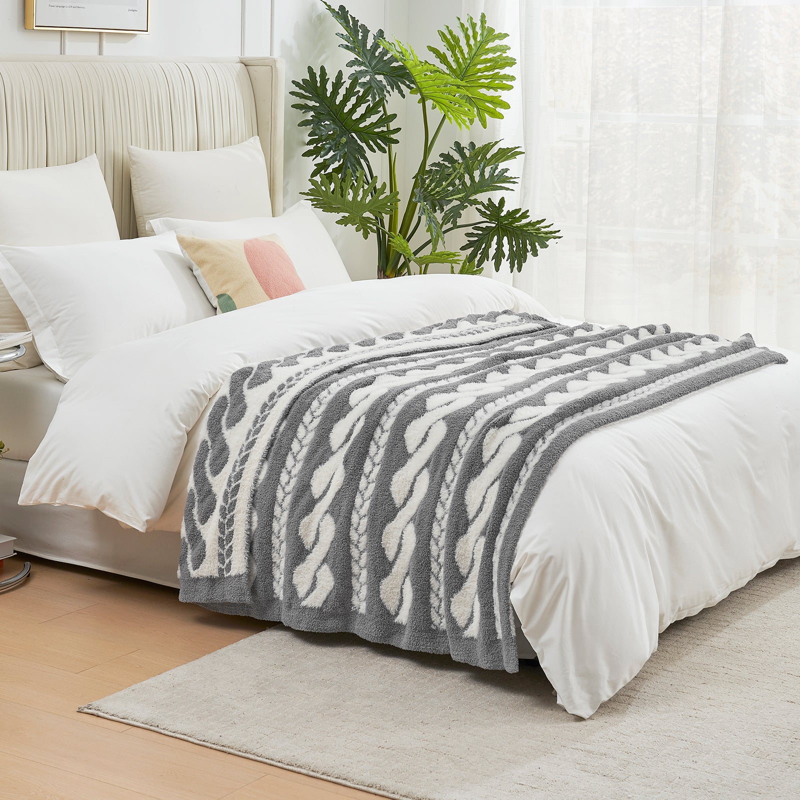 Cable pattern Faux Fur Knit Throw Blanket in gray and white on a bed side view.#color_Gray