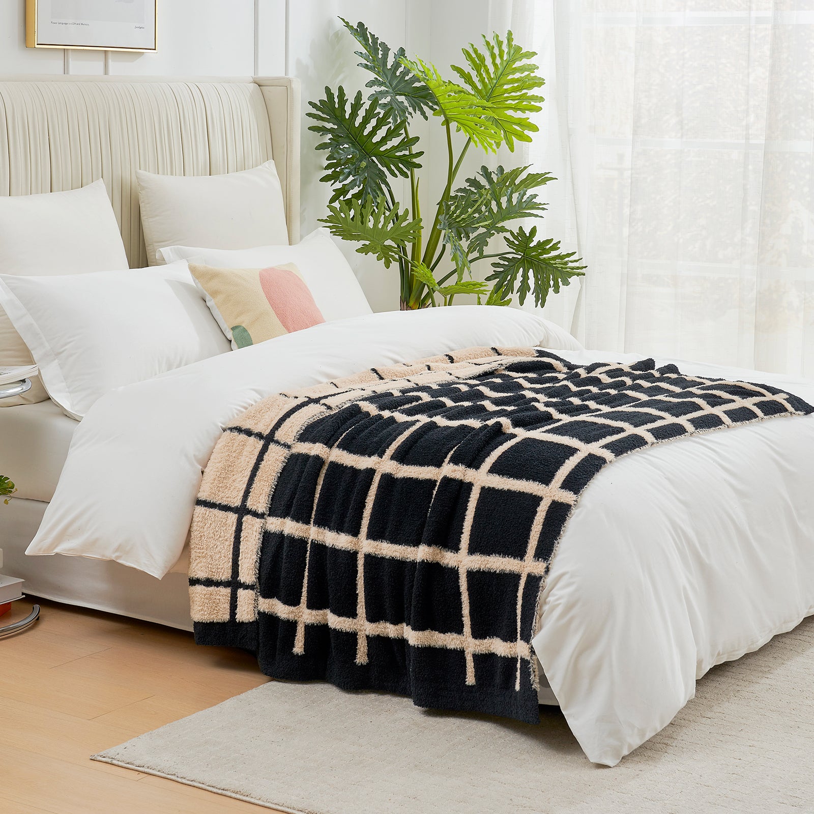 Black and beige checkered faux fur knit throw blanket on the bed.#color_Black
