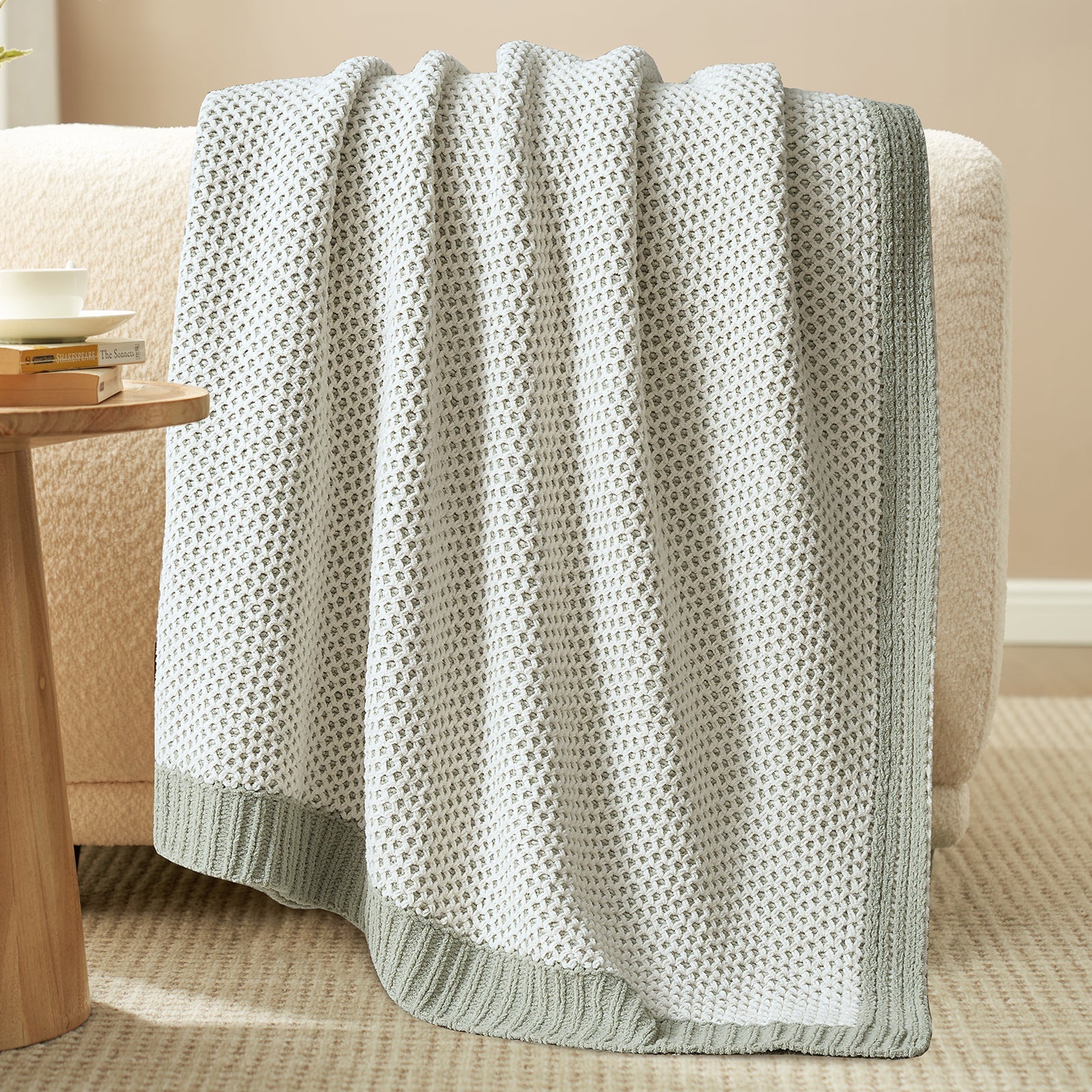 Textured blanket draped over a chair in a cozy living room setting. #color_Sage Green
