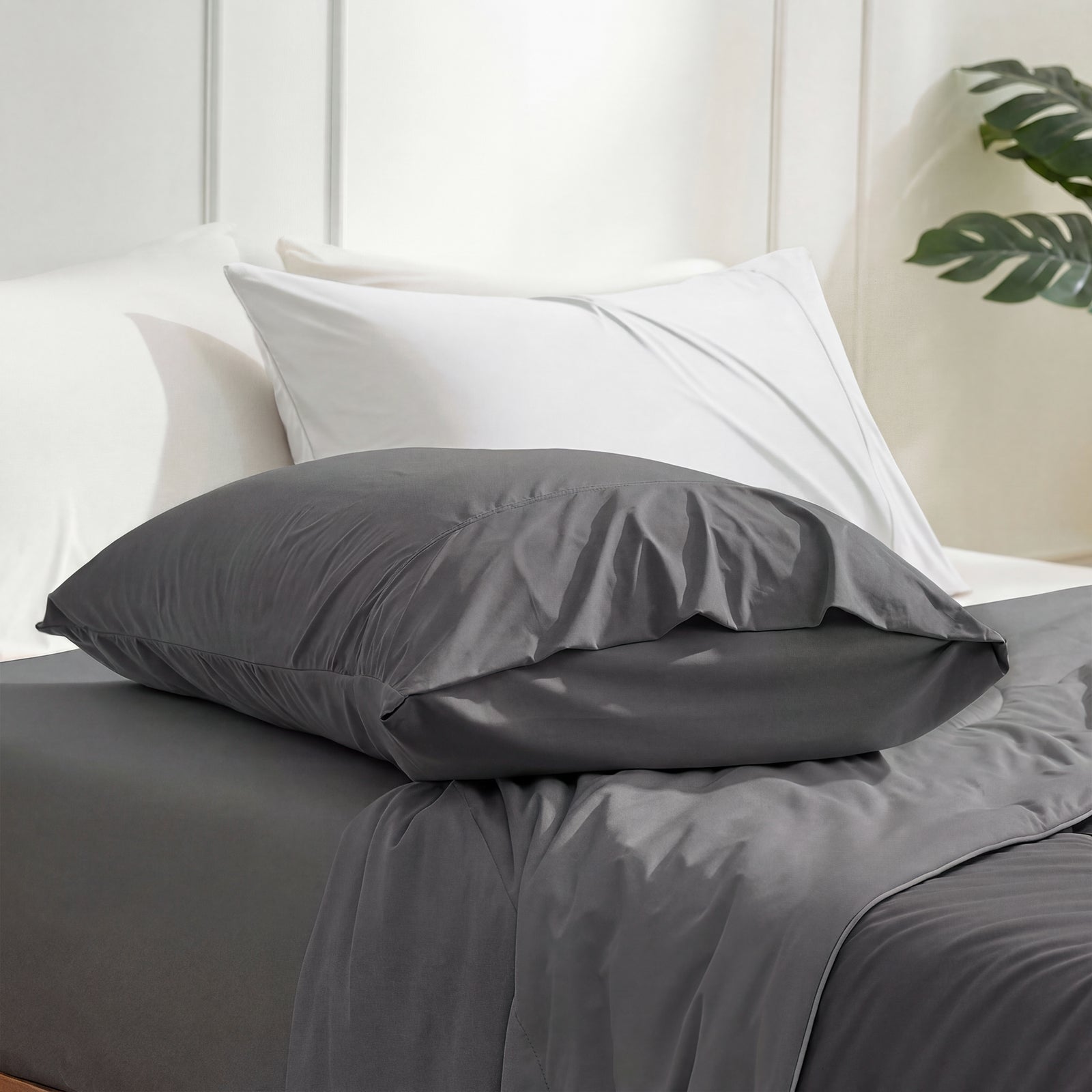 Gray bedding set with pillows on a bed in a bedroom setting.#color_Charcoal Grey