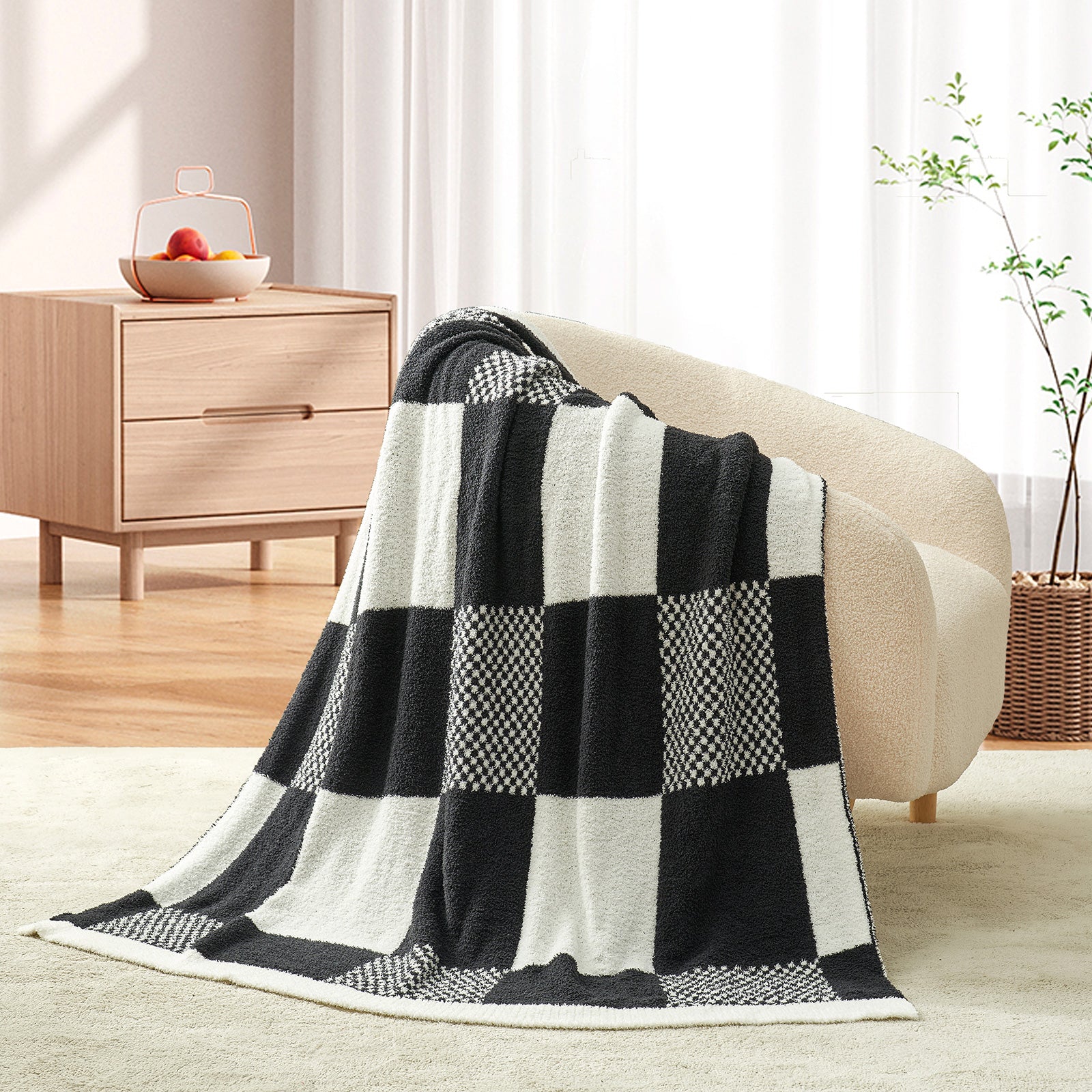 Black and white checkered blanket draped over a beige sofa in a living room. #color_Black White