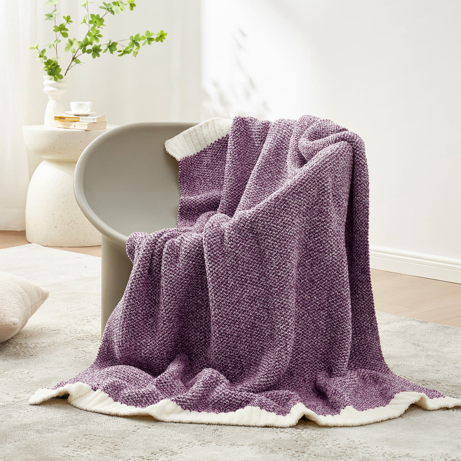 Purple textured blanket draped over a chair in a cozy living room setting. #color_Heather Purple