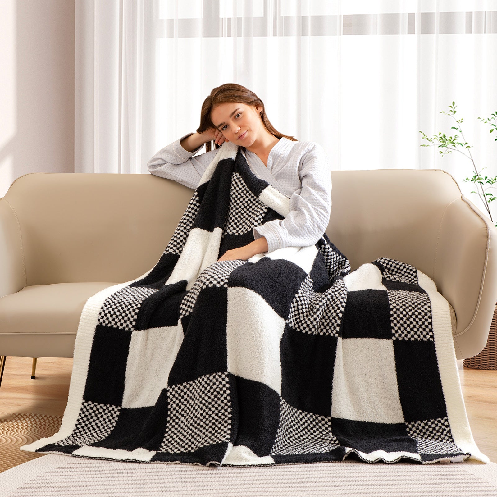 Woman sitting on a couch with a black and white checkered blanket #color_Black White