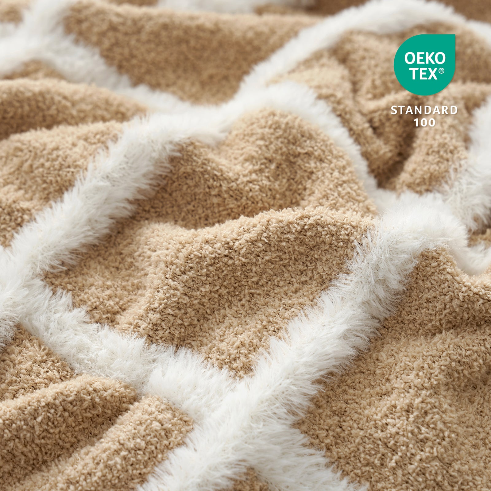 Close-up of textured fabric blanket with a geometric pattern, featuring the Oeko-Tex Standard 100 logo.#color_Beige