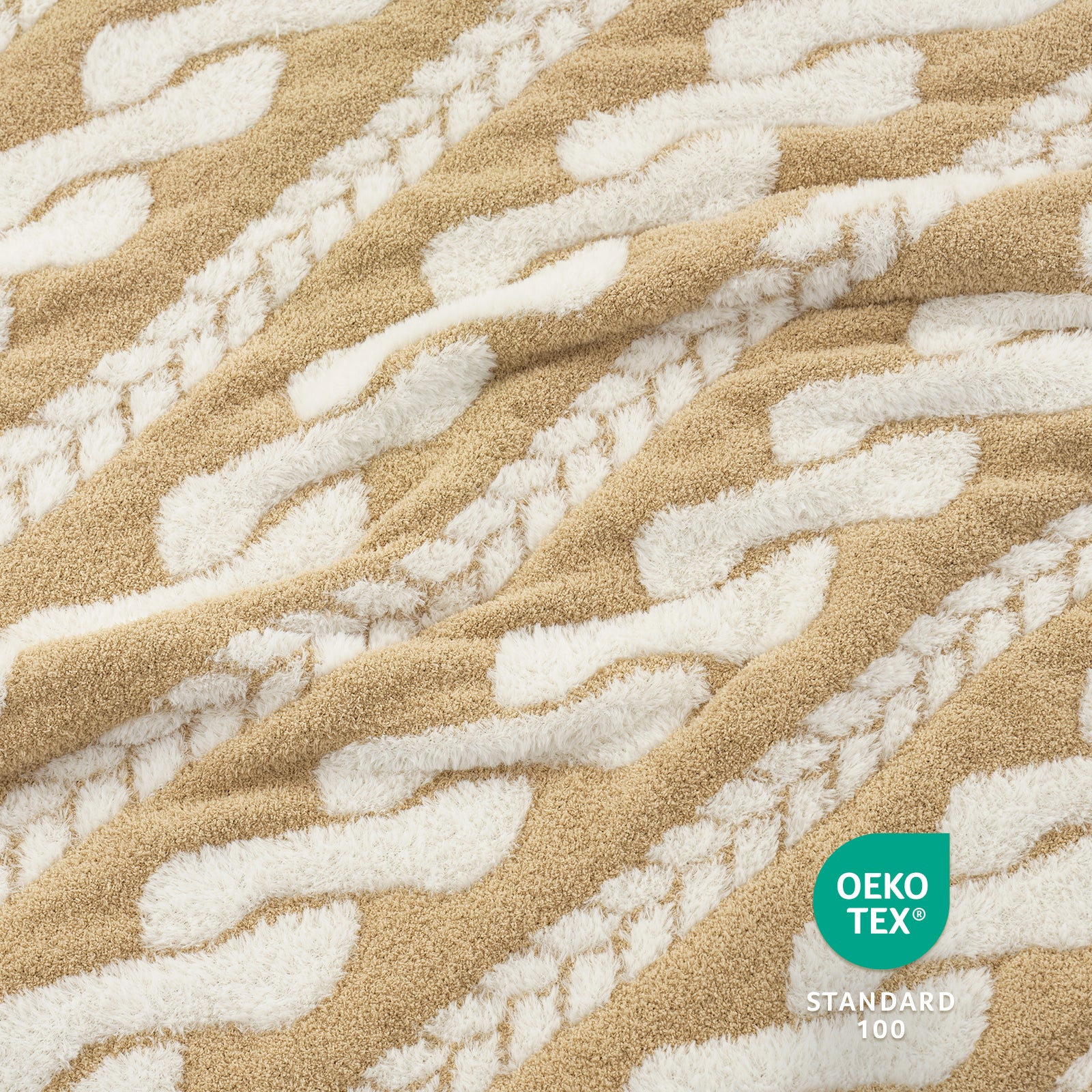 Close-up of Snuggle Sac beige and white Cable pattern Faux Fur Knit Throw Blanket textured fabric with OEKO-TEX logo.#color_Beige