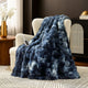 Snuggle Sac bubble faux fur electric blanket in Tie-dye Blue draped over a chair with controller, creating a warm and cozy setting #color_Tie-dye Blue